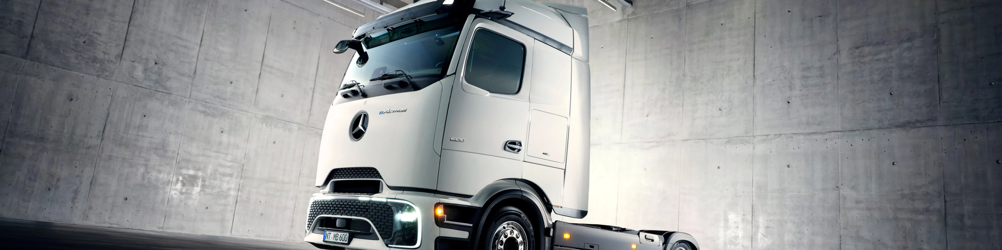Autonomes Lkw-Fahrgestell in Industriehalle unter Scheinwerfern.