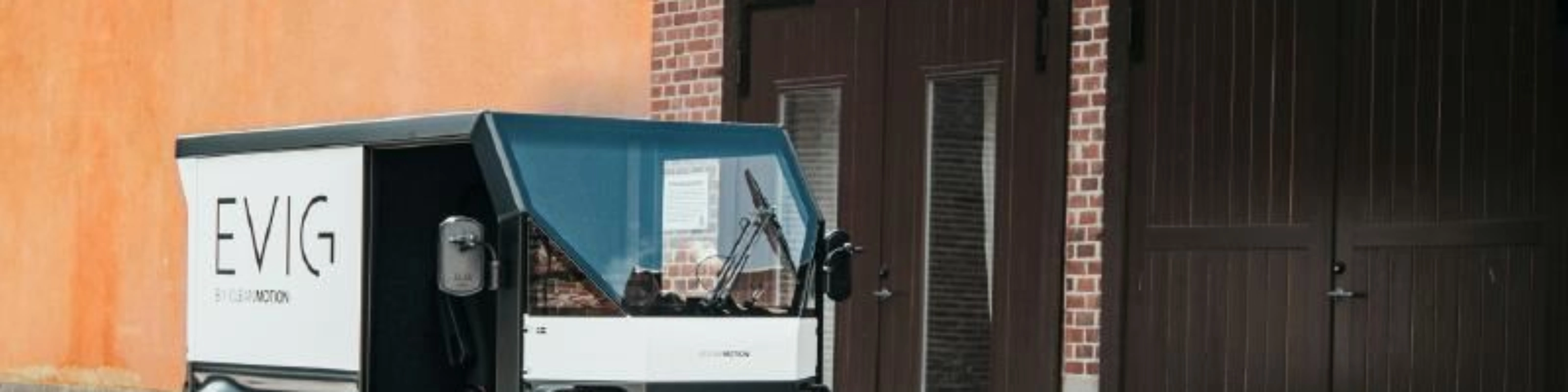 CleanMotion EVIG electric cargo vehicle parked beside a building.