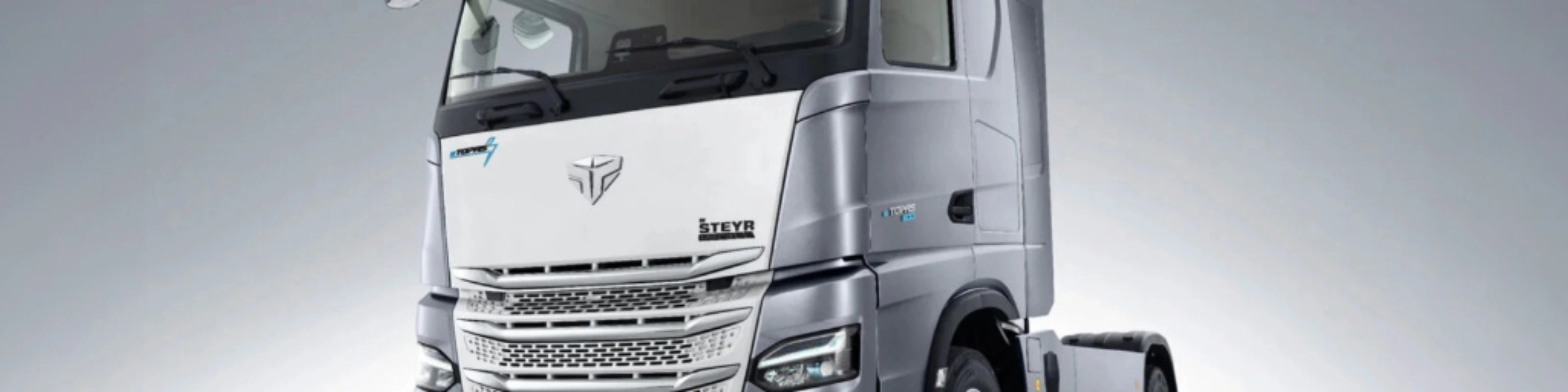 Silver Steyr semi-truck cab in studio view from the front left.