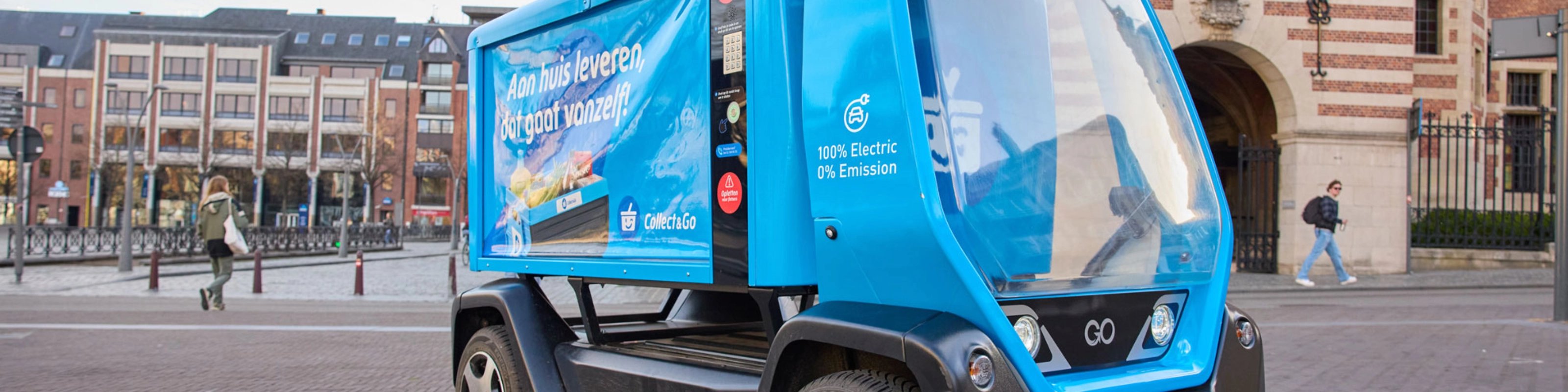 Kleines blaues Elektro-Müllfahrzeug auf einem Stadtplatz.