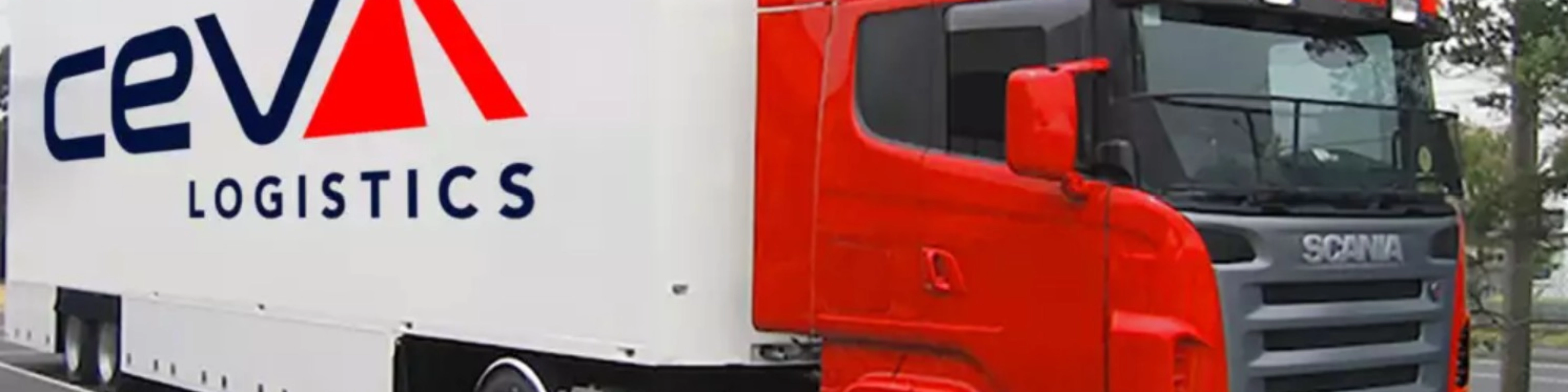 A red CEVA Logistics truck with trailer is parked on a street.