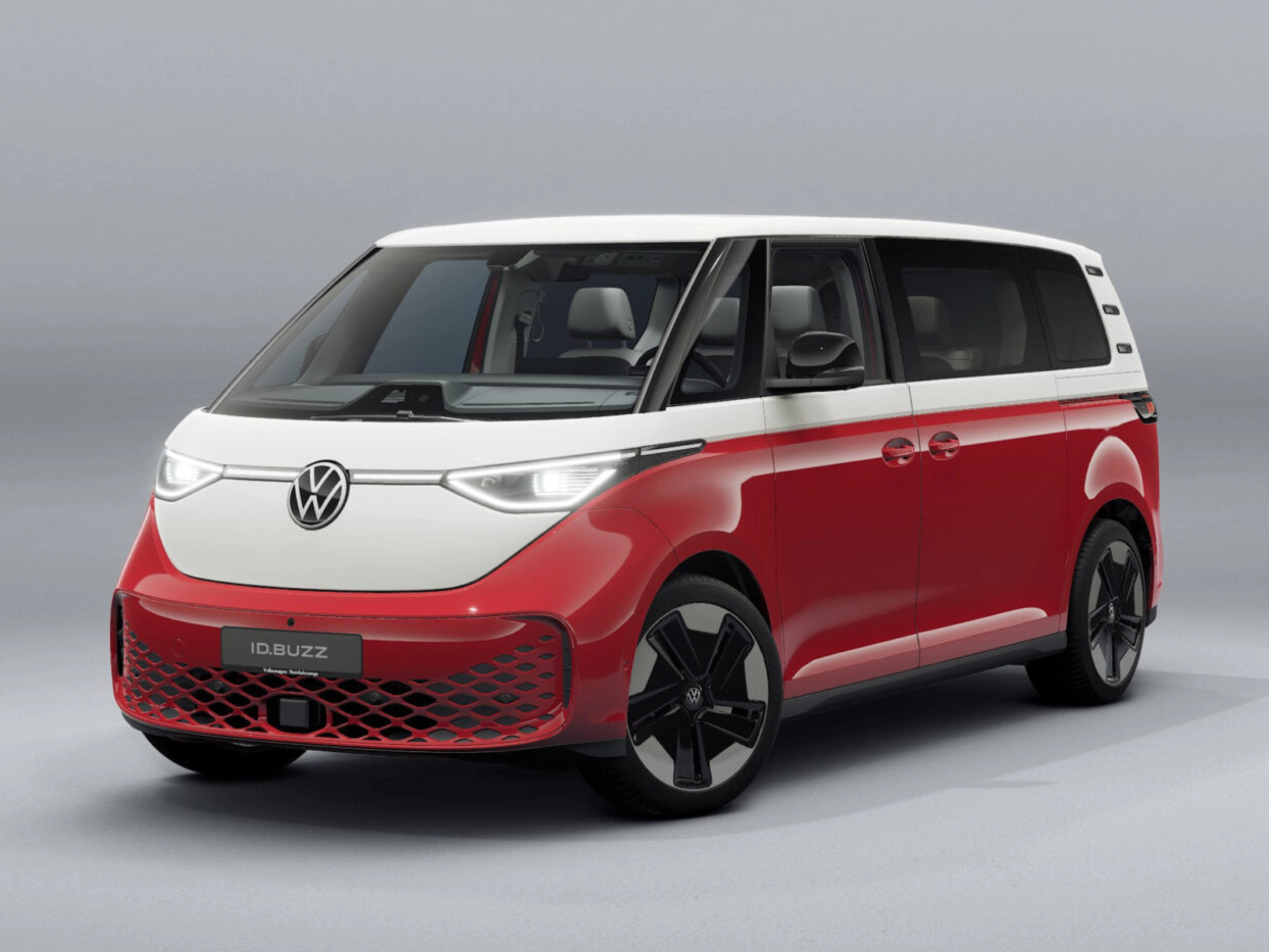 Red and white Volkswagen van in front view on a neutral studio background.