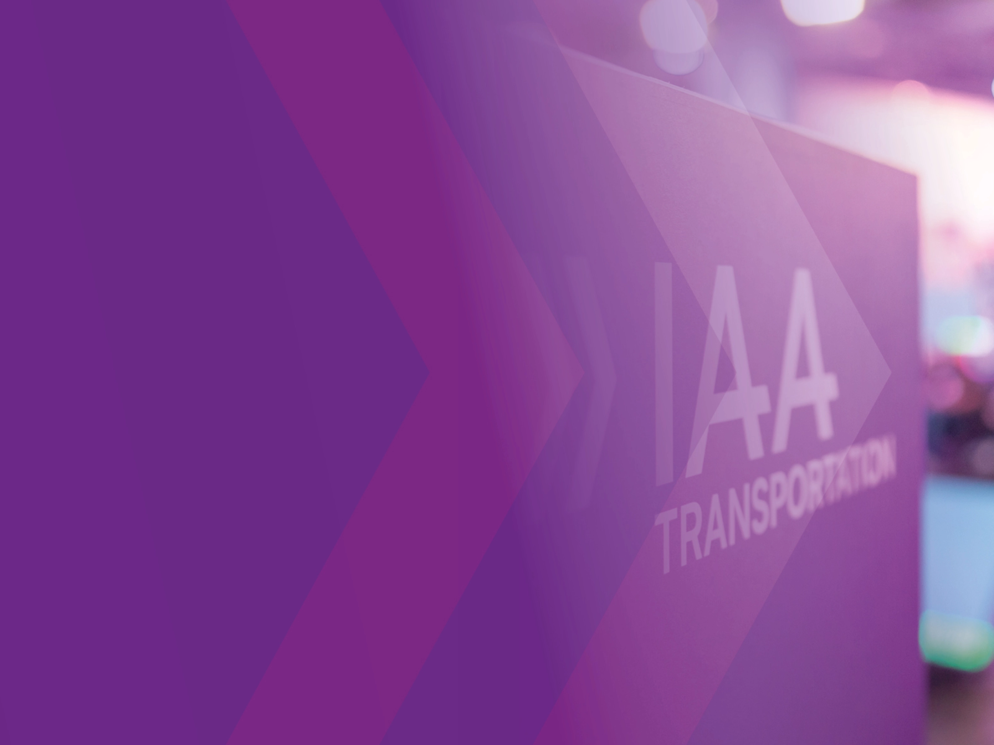 Schild mit der Aufschrift „IAA TRANSPORTATION“ auf einer Messe, lila Gestaltung im Vordergrund.
