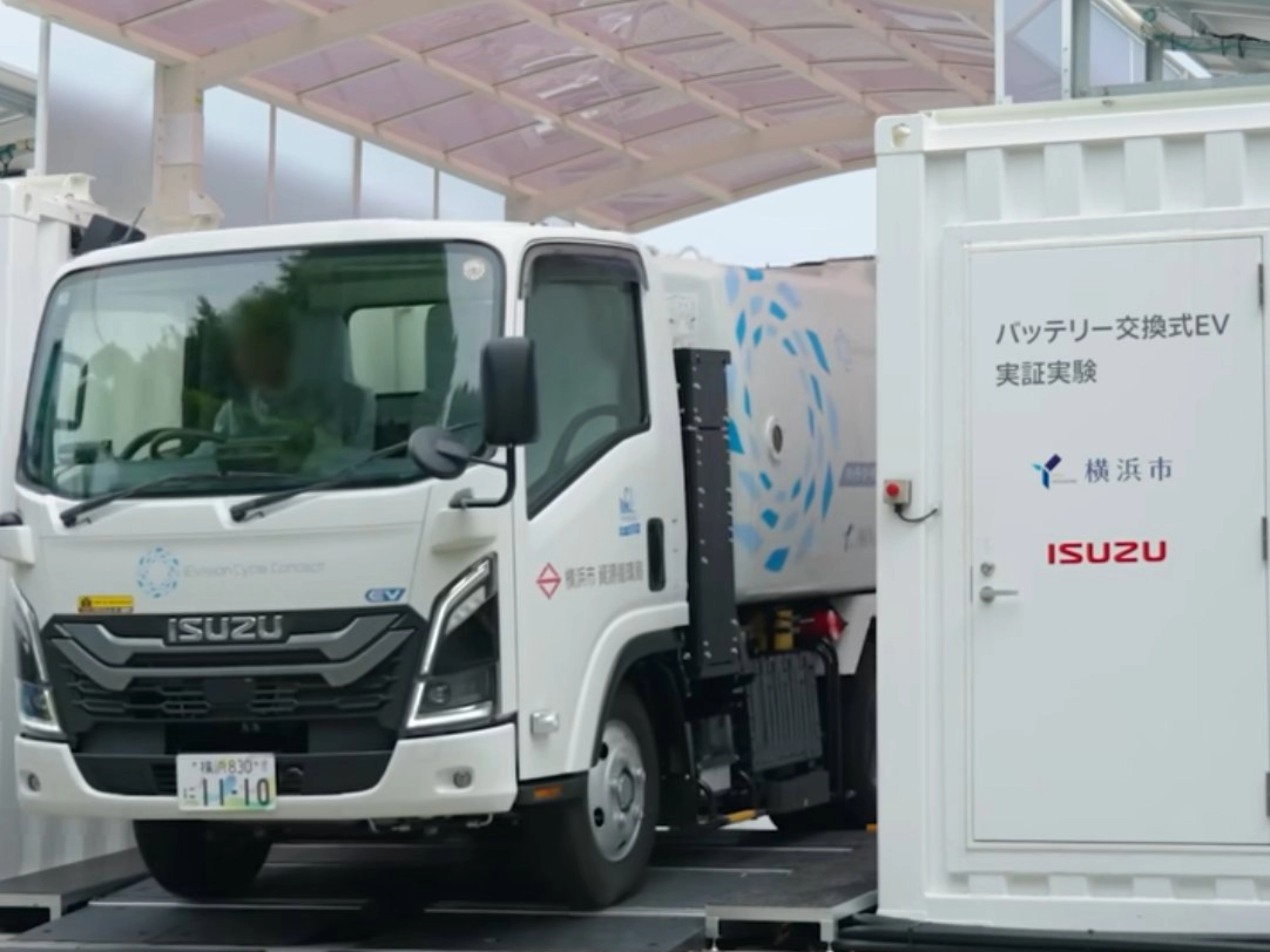 Isuzu truck displayed at an exhibition beside an information board.