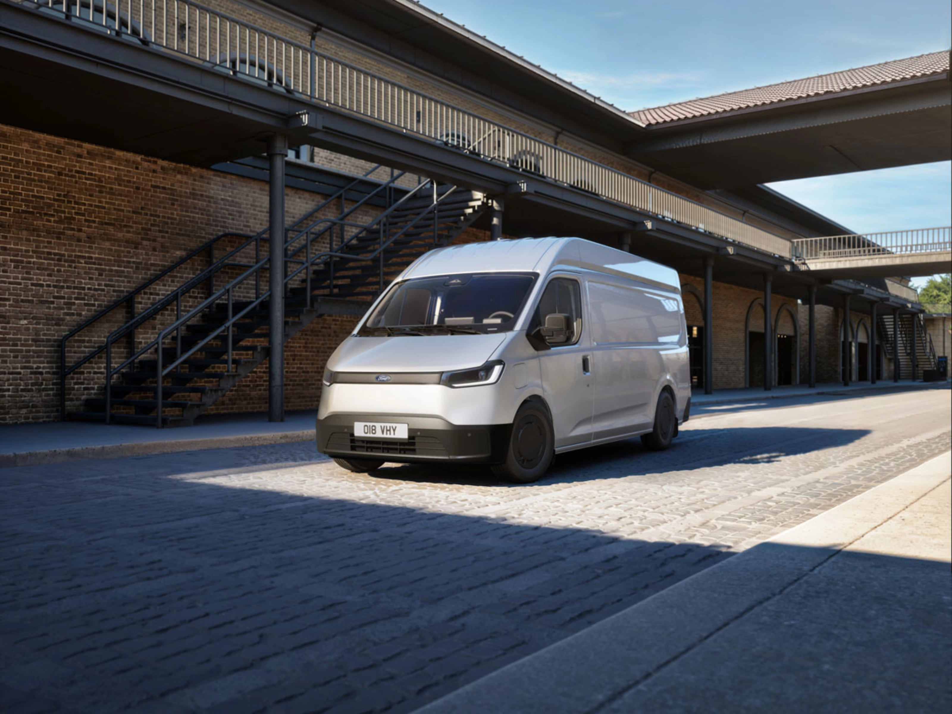 White van parked in a courtyard in front of a brick building