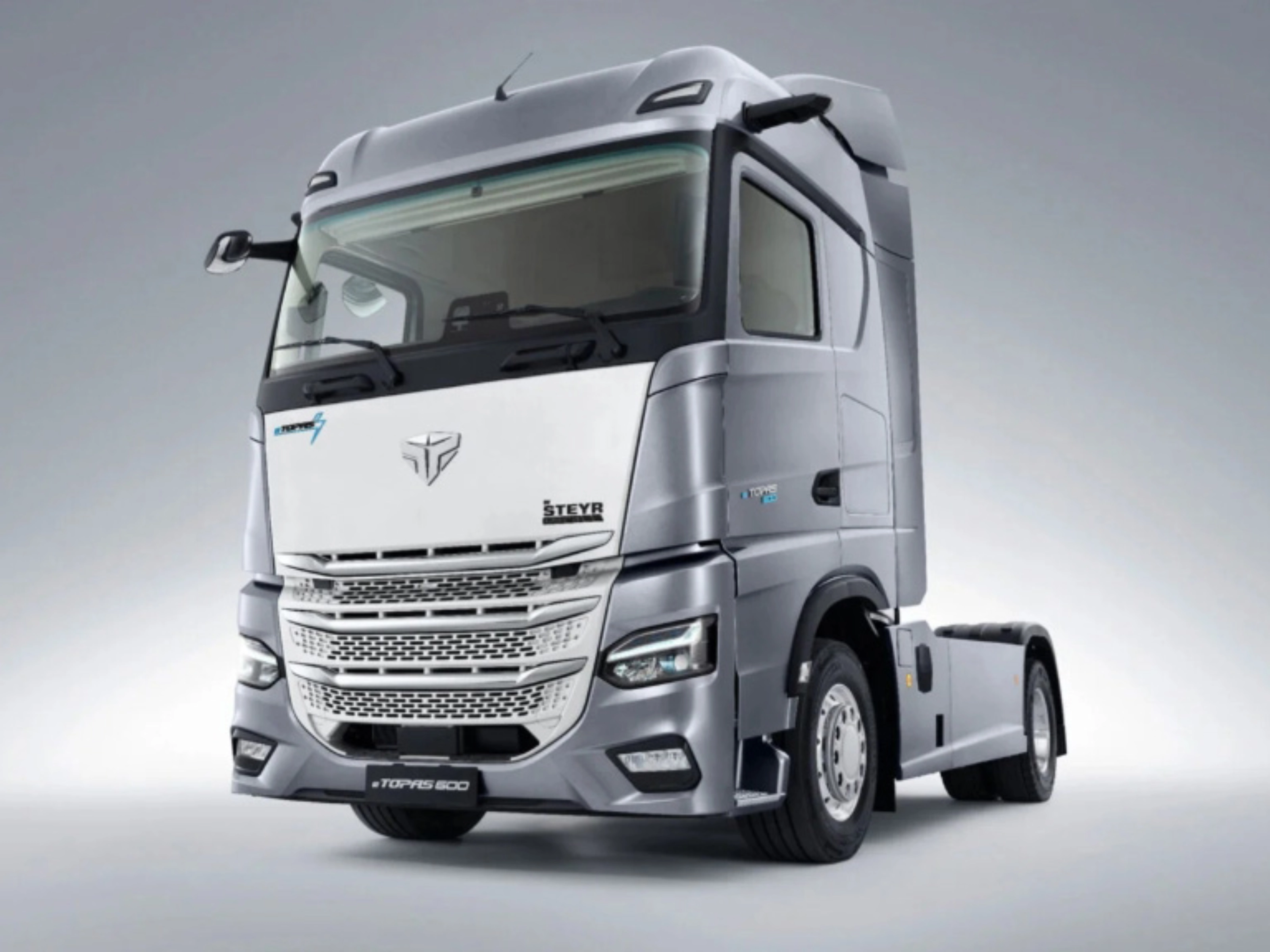 Silver Steyr semi-truck cab in studio view from the front left.