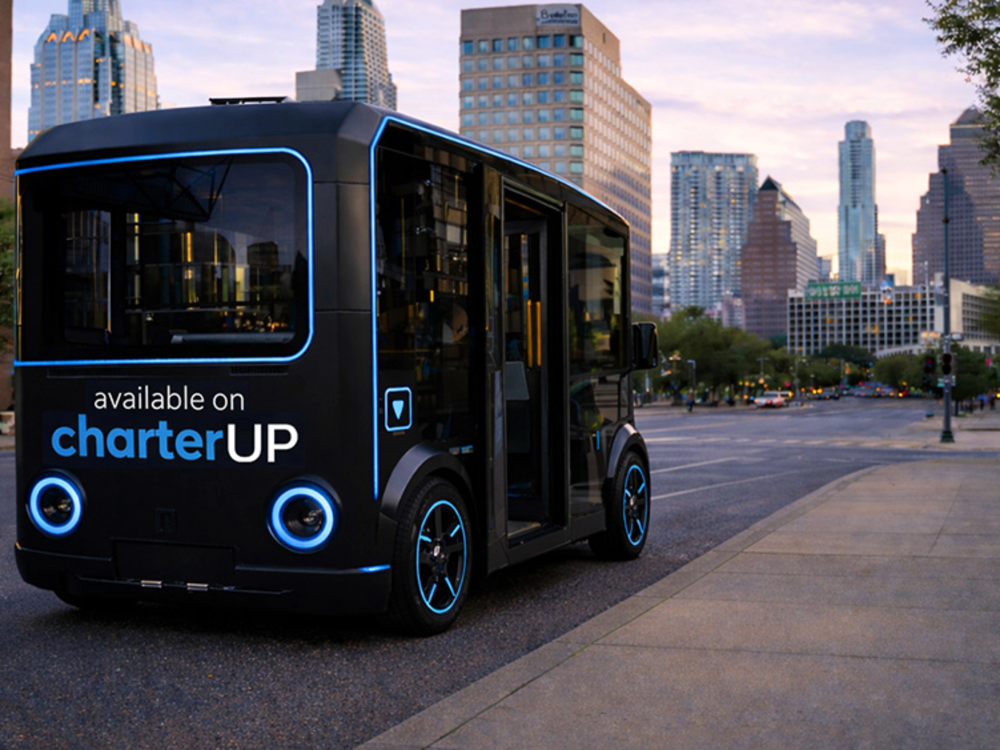 Small black electric shuttle bus with CharterUP logo in city street.