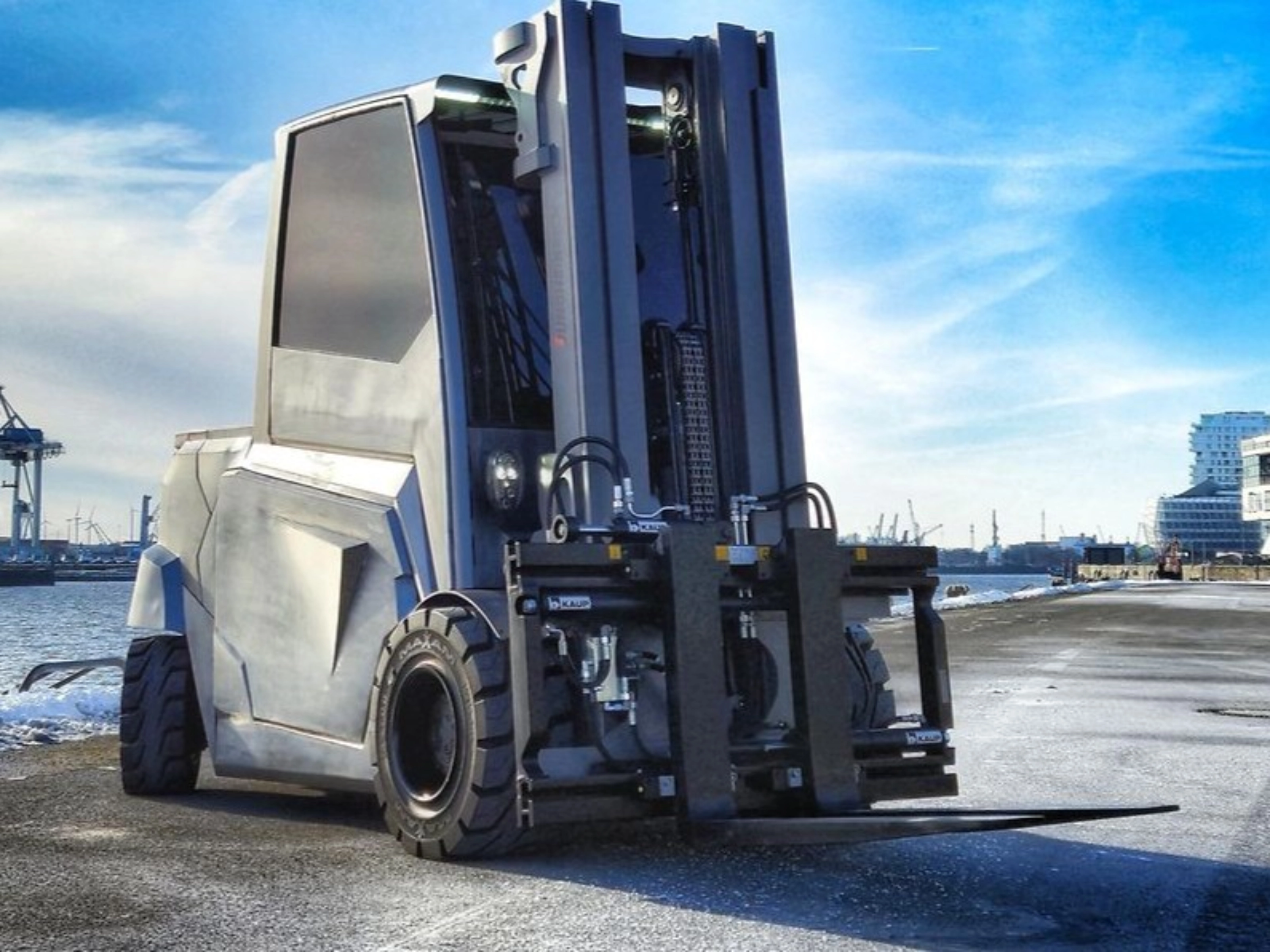 Large industrial forklift parked at a harbor loading area.