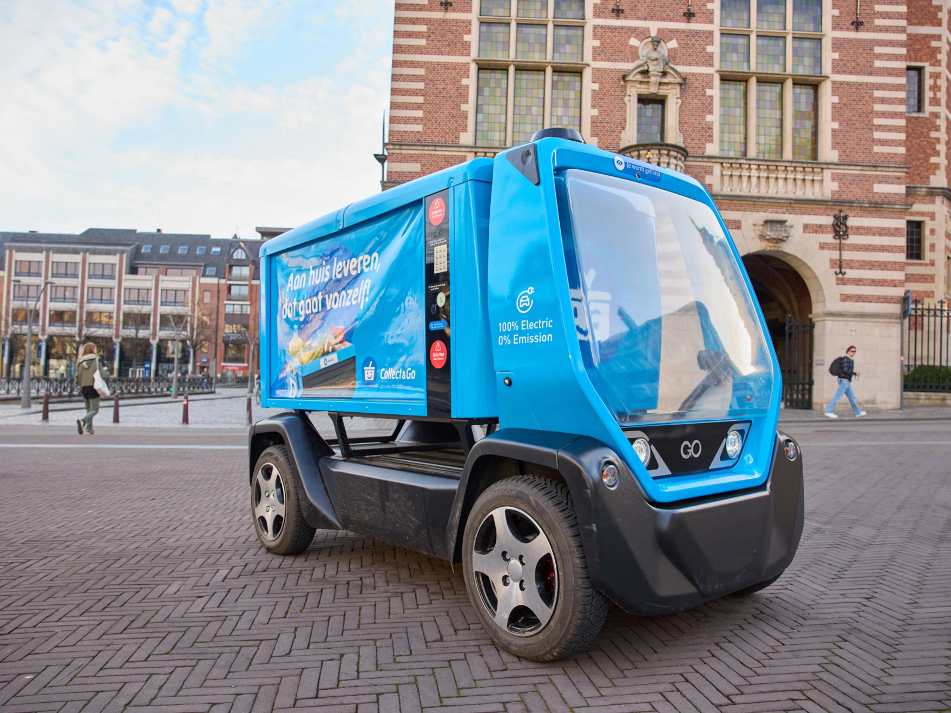 Kleines blaues Elektro-Müllfahrzeug auf einem Stadtplatz.
