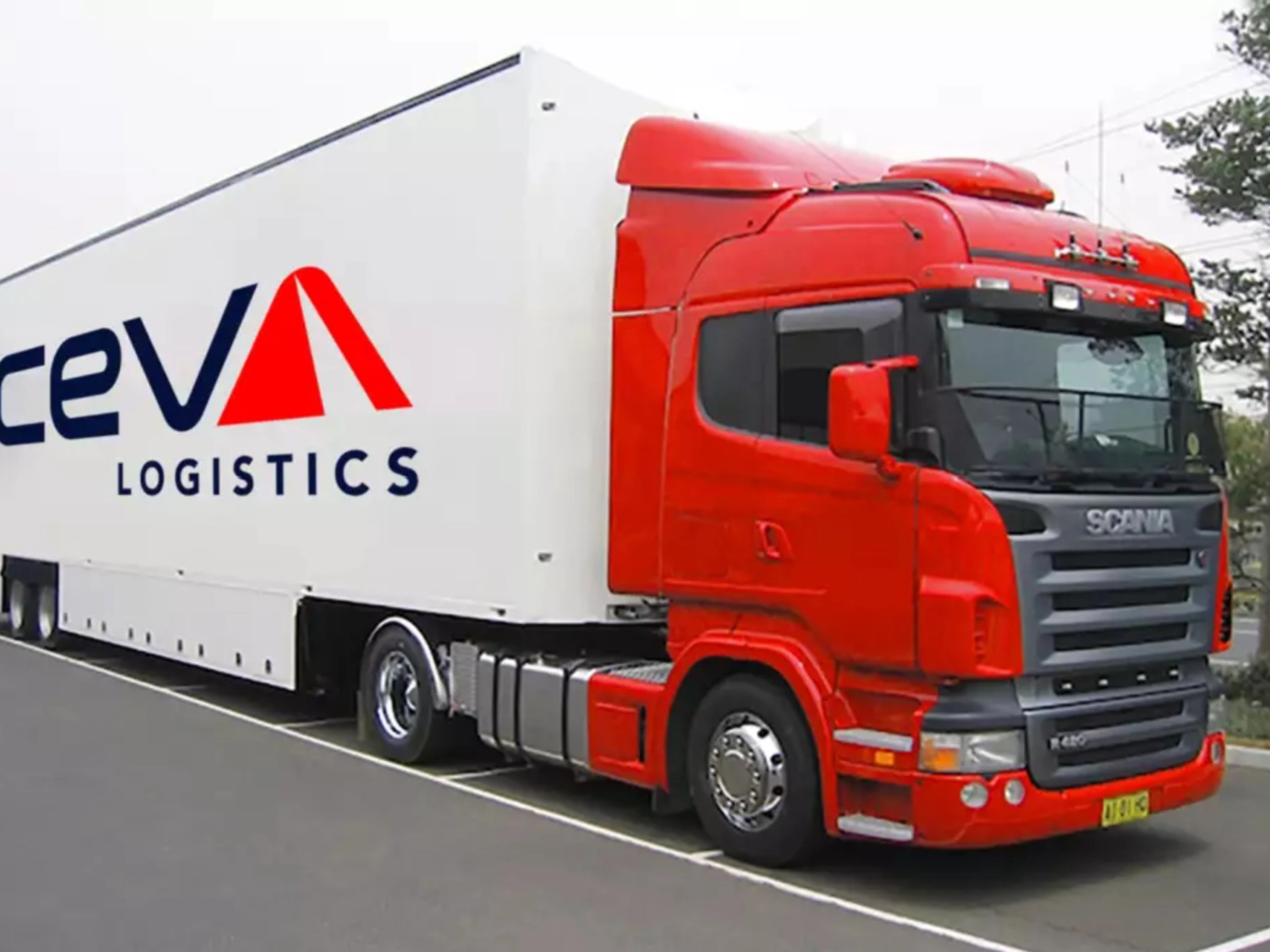A red CEVA Logistics truck with trailer is parked on a street.