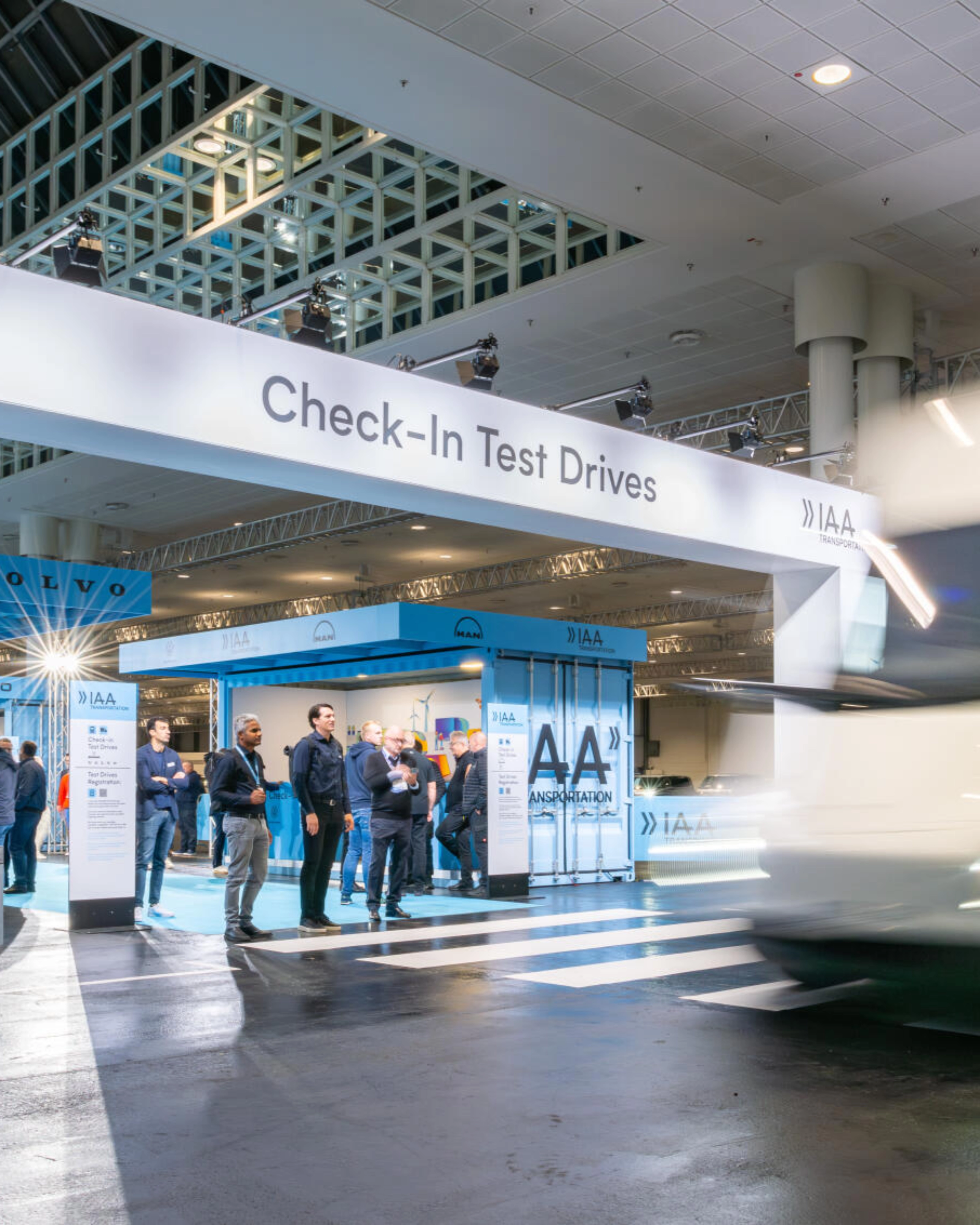 IAA Transportation Check-In area for test drives with truck passing by.