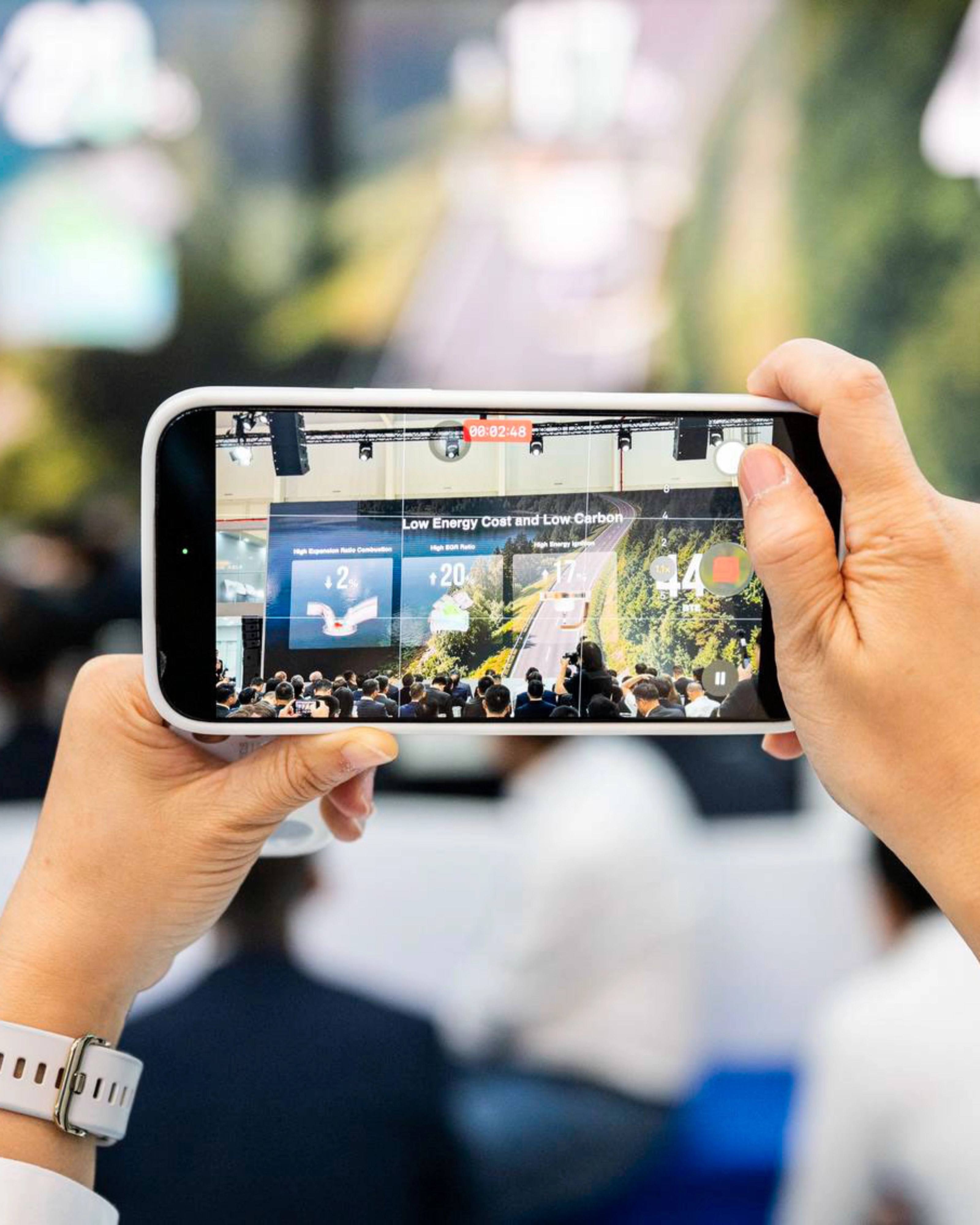 Person taking a photo of an event with a smartphone.