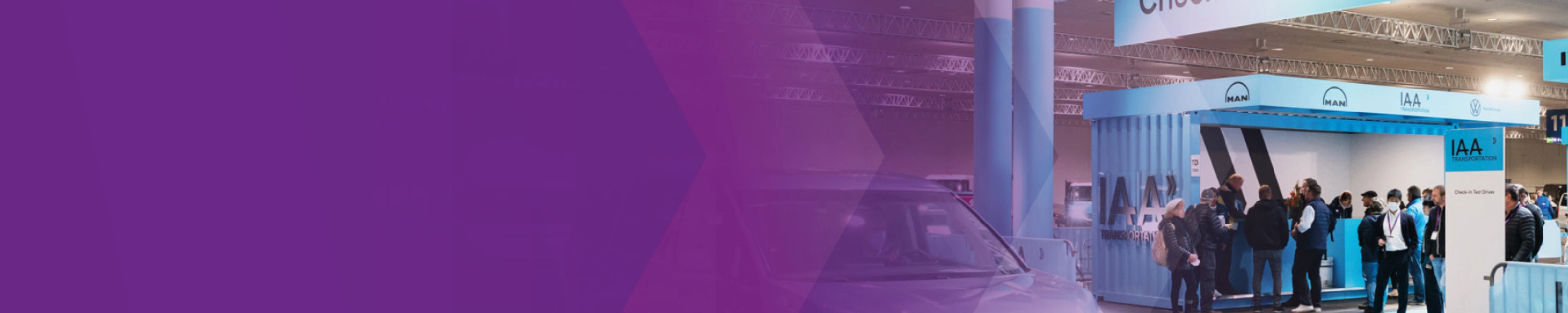 Check‑in‑Bereich für Probefahrten der IAA Transportation mit Fahrzeug und Personen in einer Halle.