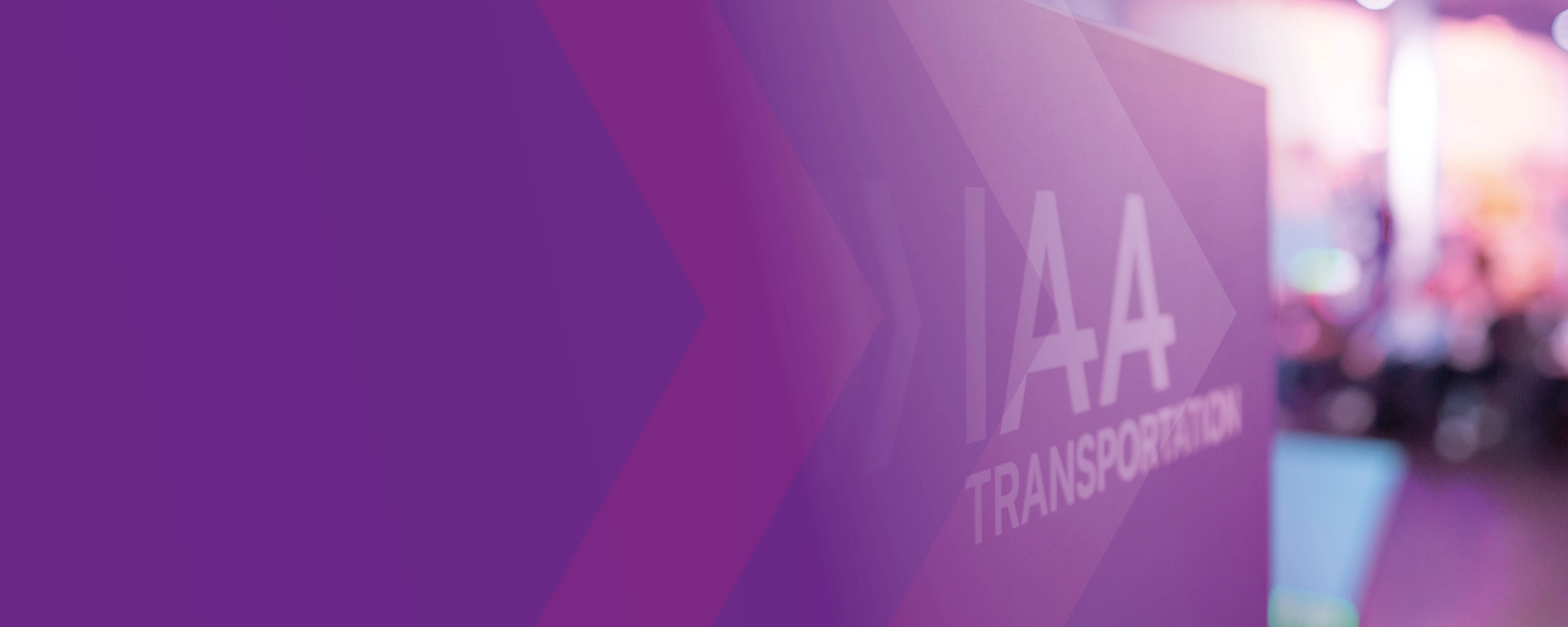 Schild mit der Aufschrift „IAA TRANSPORTATION“ auf einer Messe, lila Gestaltung im Vordergrund.