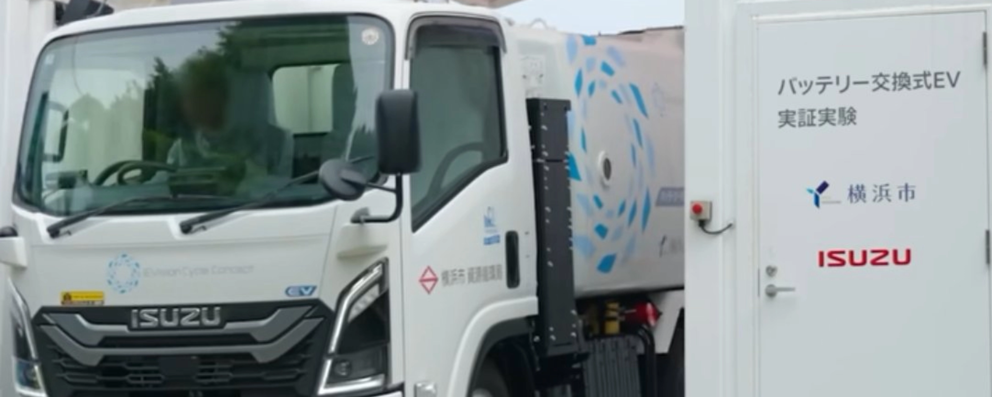 Isuzu truck displayed at an exhibition beside an information board.
