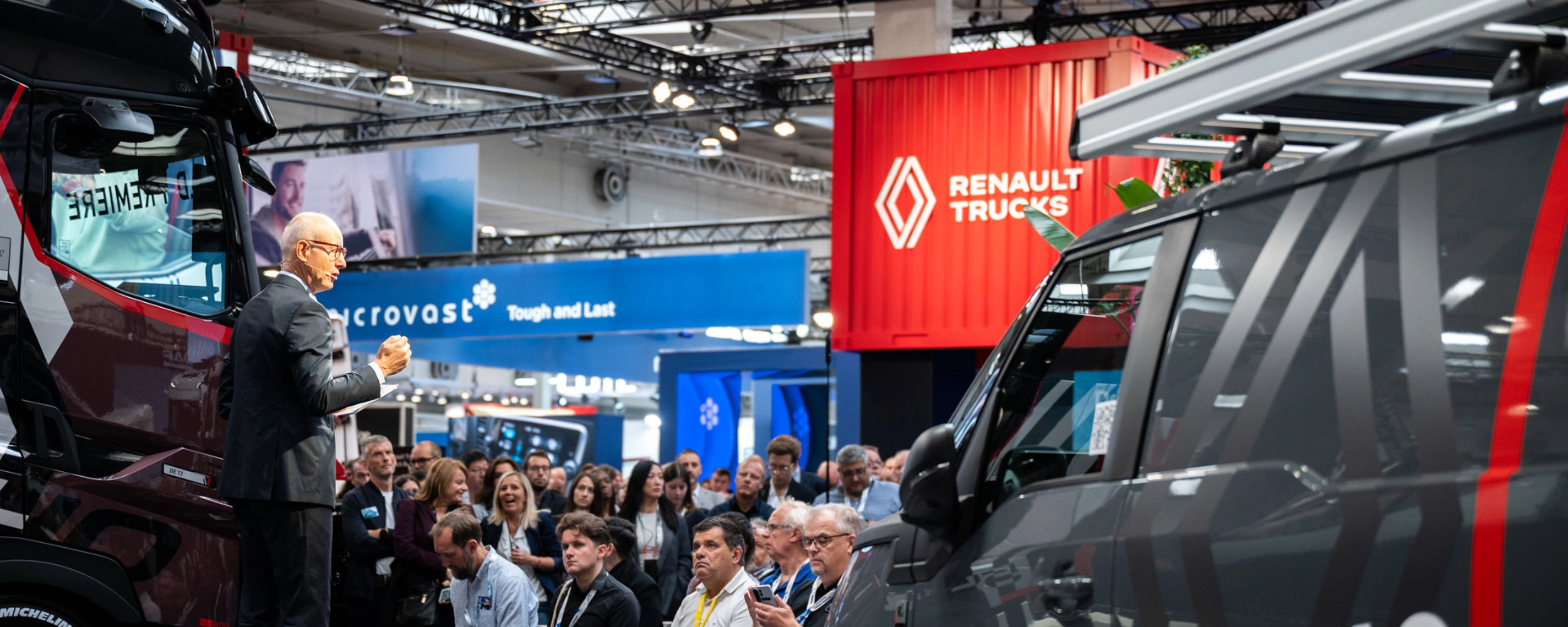 Nutzfahrzeuge und Besucher in einer gut besuchten Messehalle der IAA Transportation.