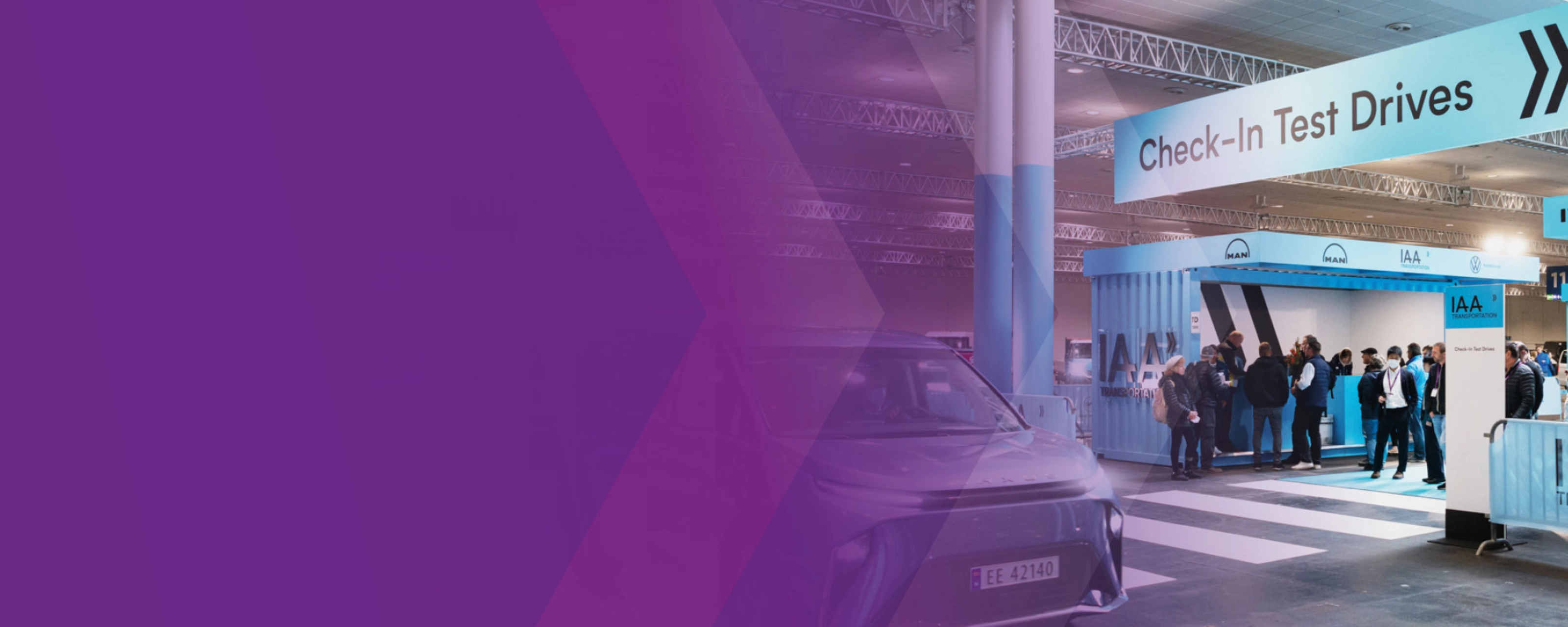 Check‑in‑Bereich für Probefahrten der IAA Transportation mit Fahrzeug und Personen in einer Halle.