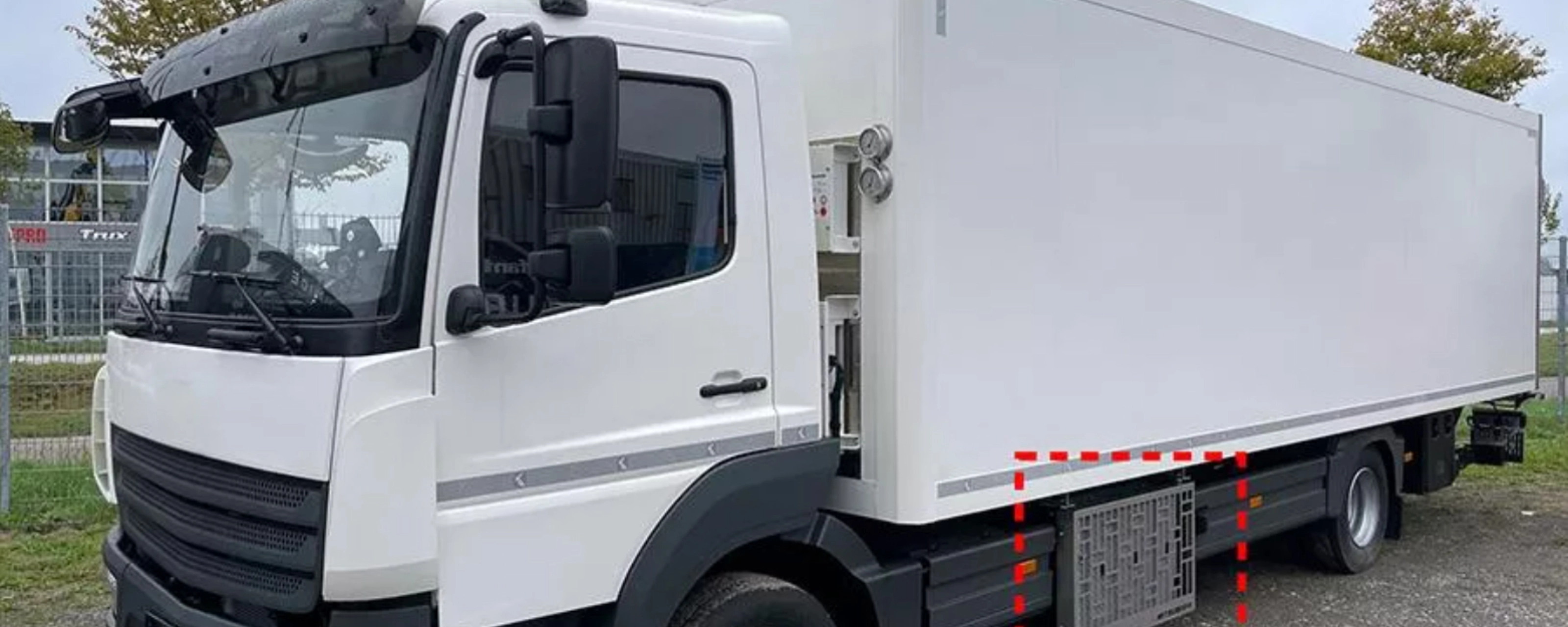 Weißer Mitsubishi Heavy Industries Koffer-Lkw mit seitlich montierten TEU-Boxen.