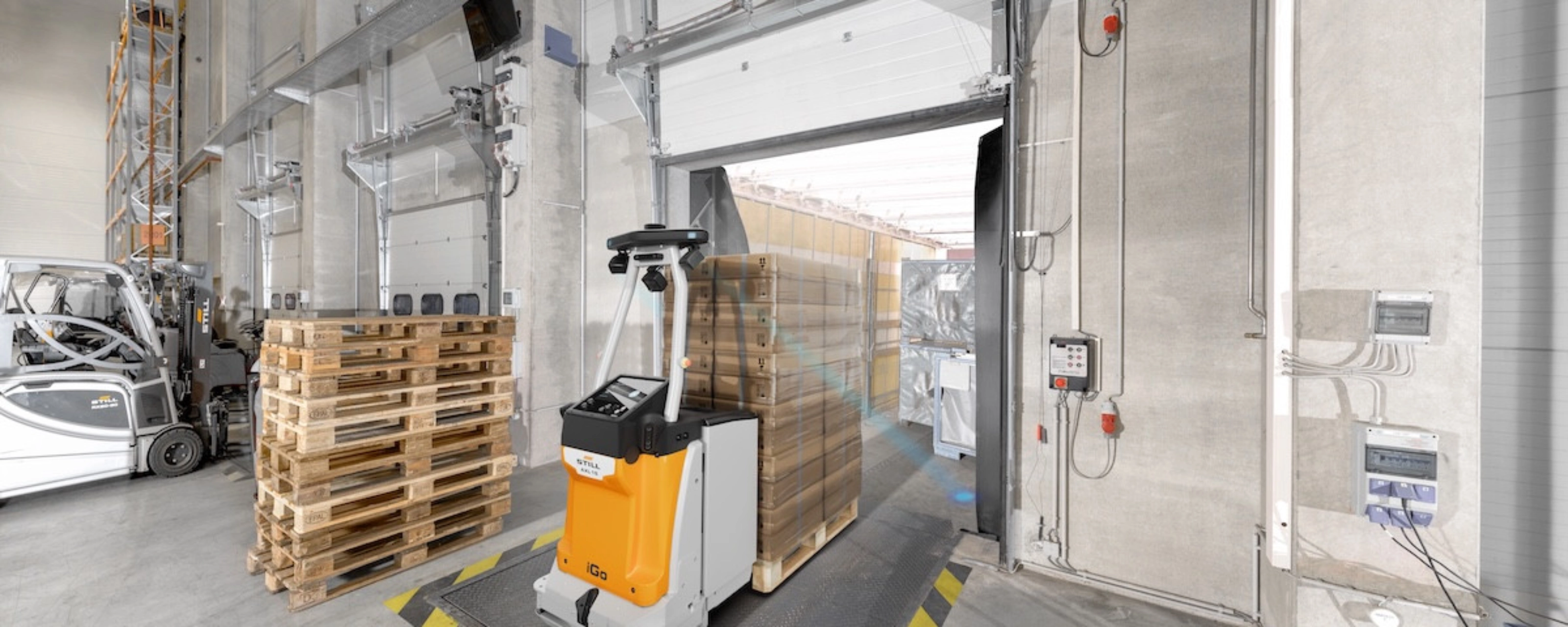 Autonomous mobile robot transporting goods at an industrial loading gate.