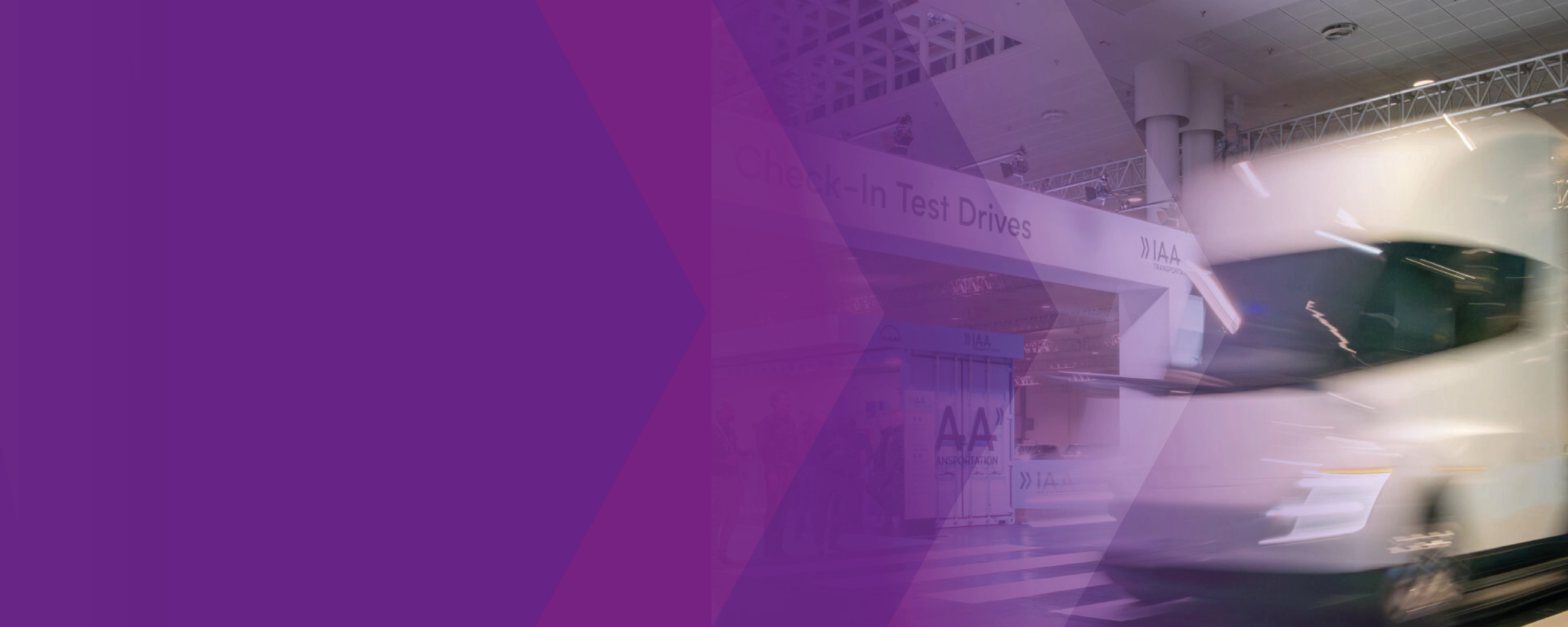 Blurred white truck at the IAA test drive area with a purple graphic overlay.