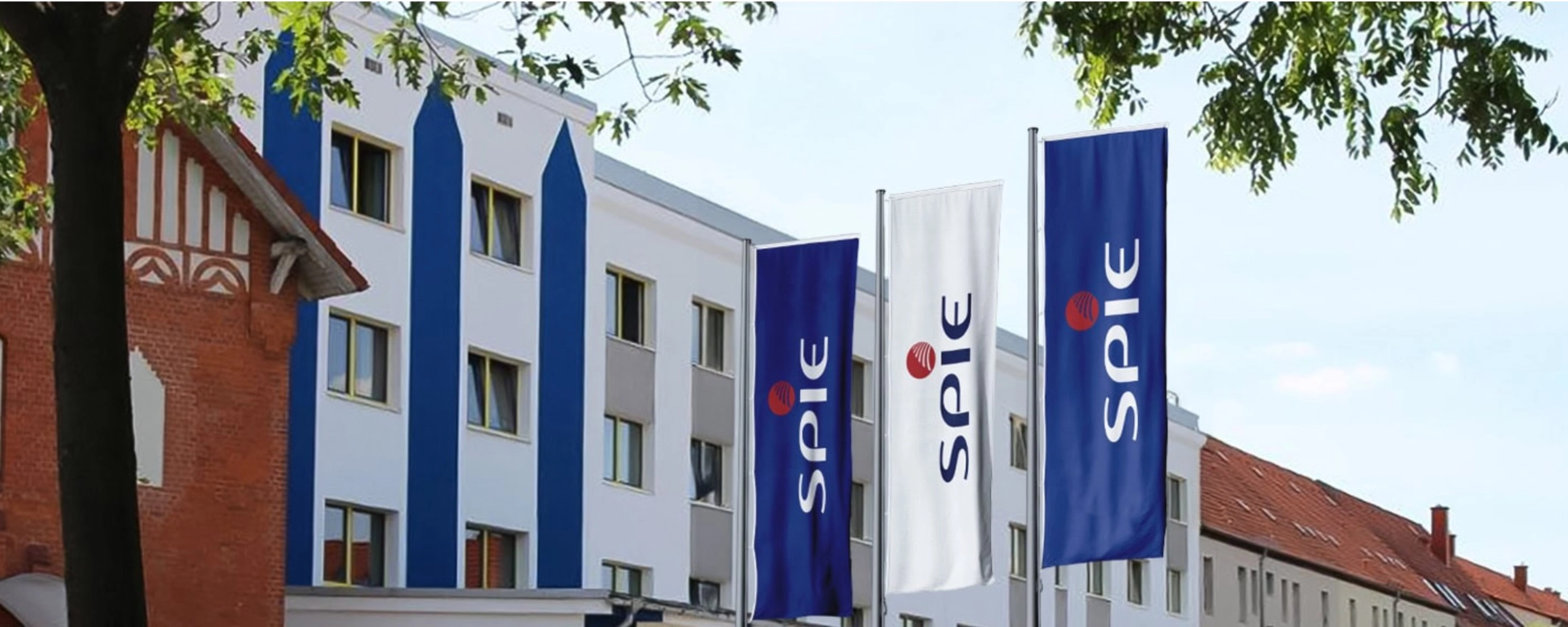 SPIE company building with blue SPIE flags displayed along the facade.