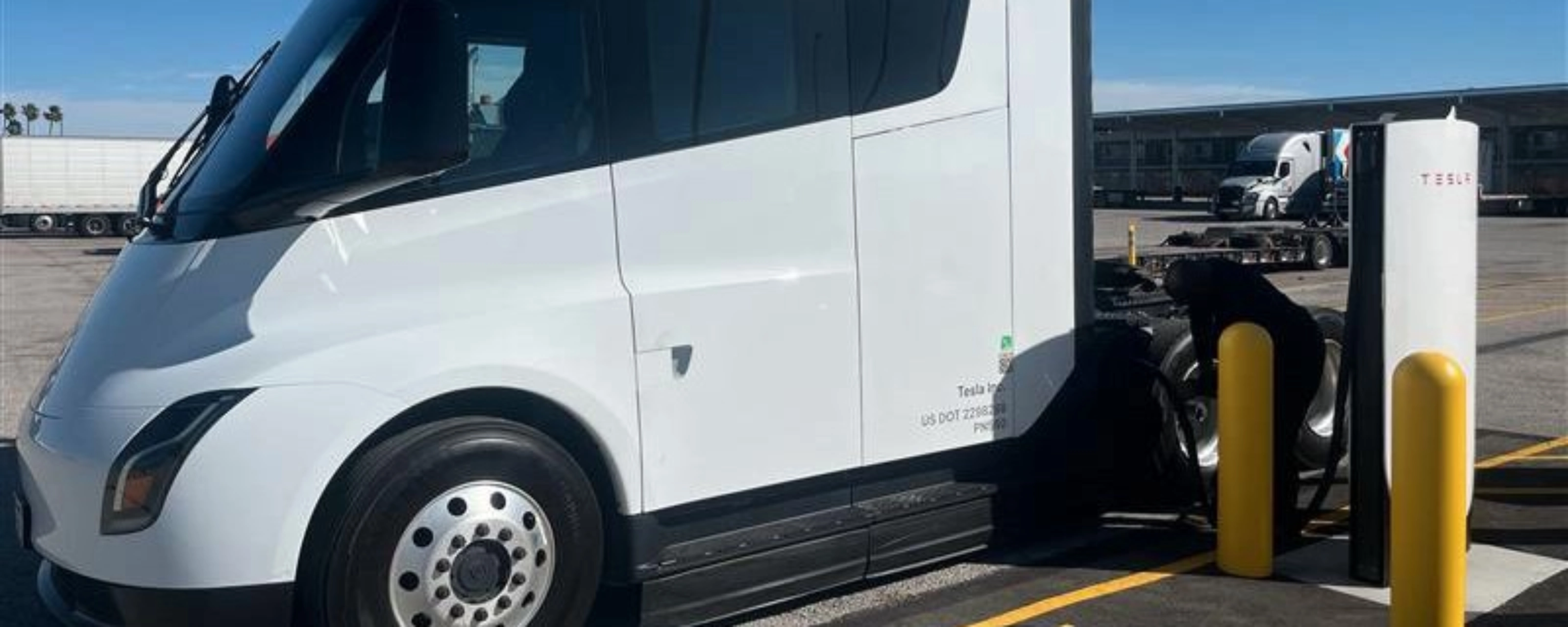 White Tesla Semi charging at a Tesla charging station.