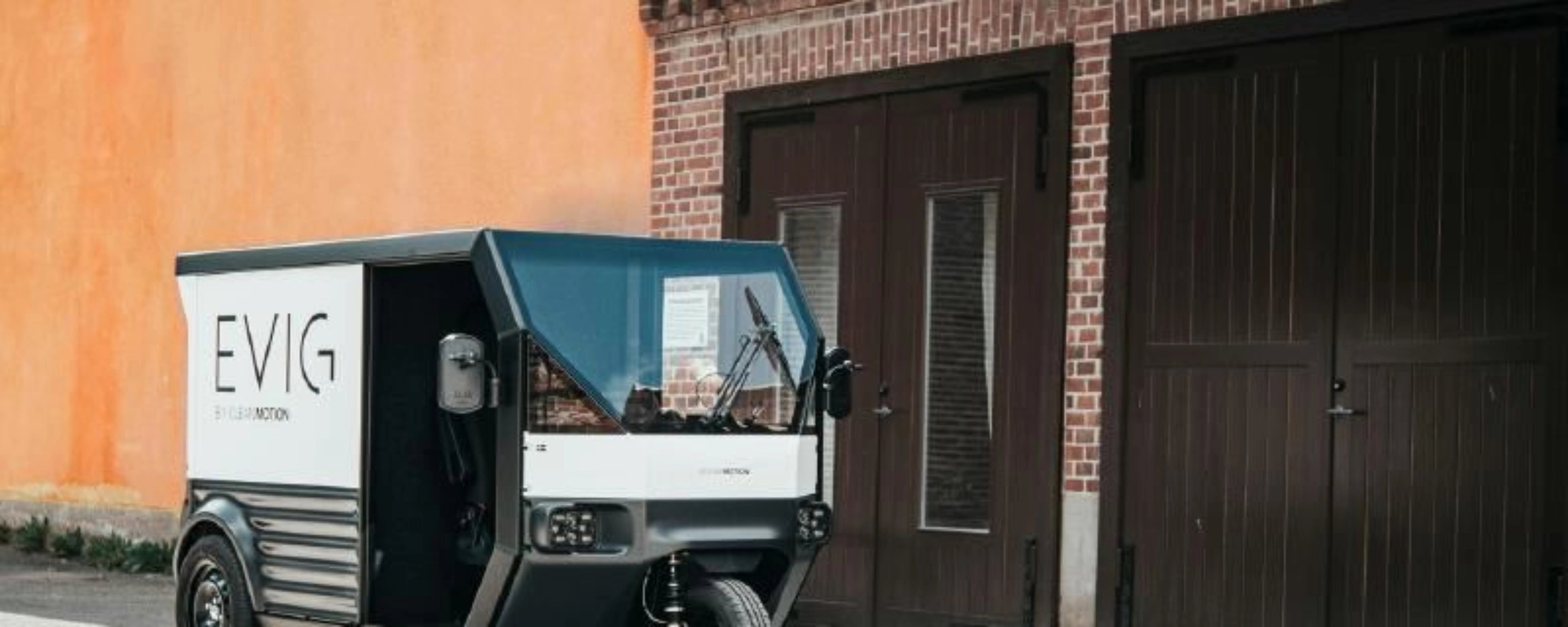 CleanMotion EVIG electric cargo vehicle parked beside a building.