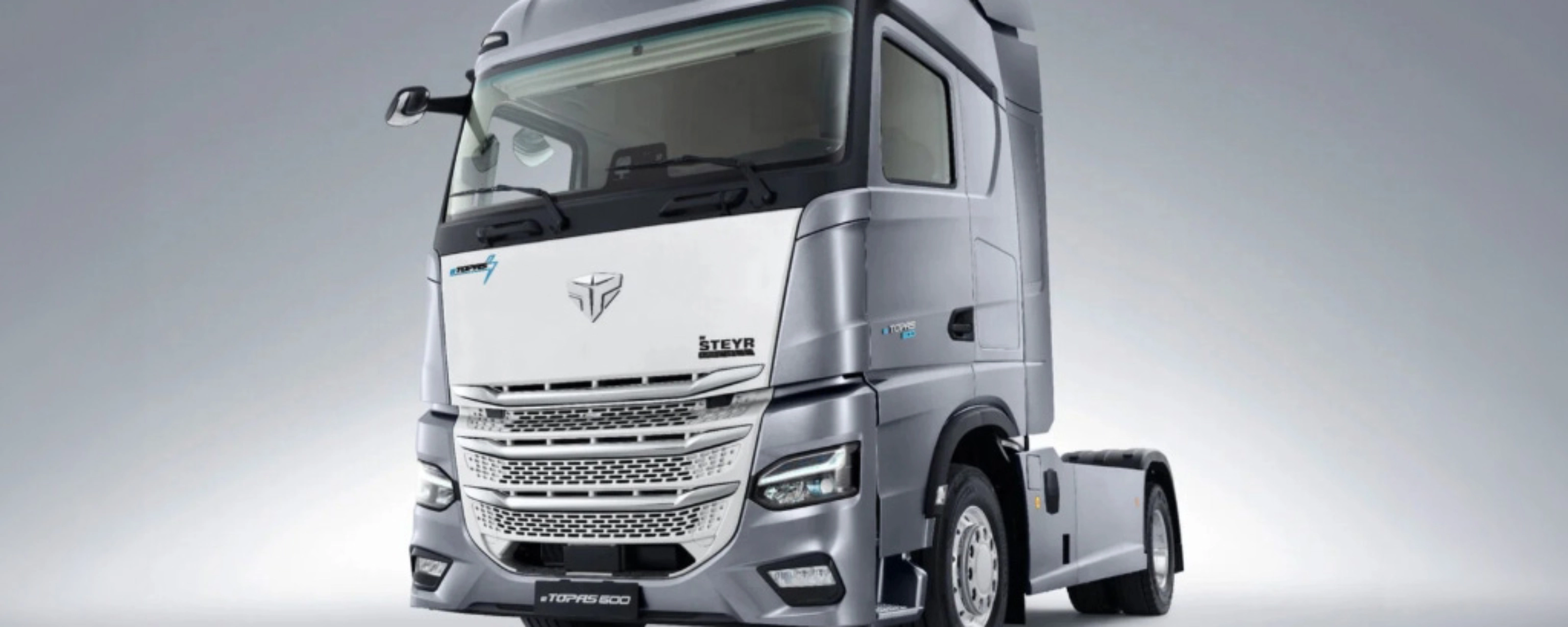 Silver Steyr semi-truck cab in studio view from the front left.