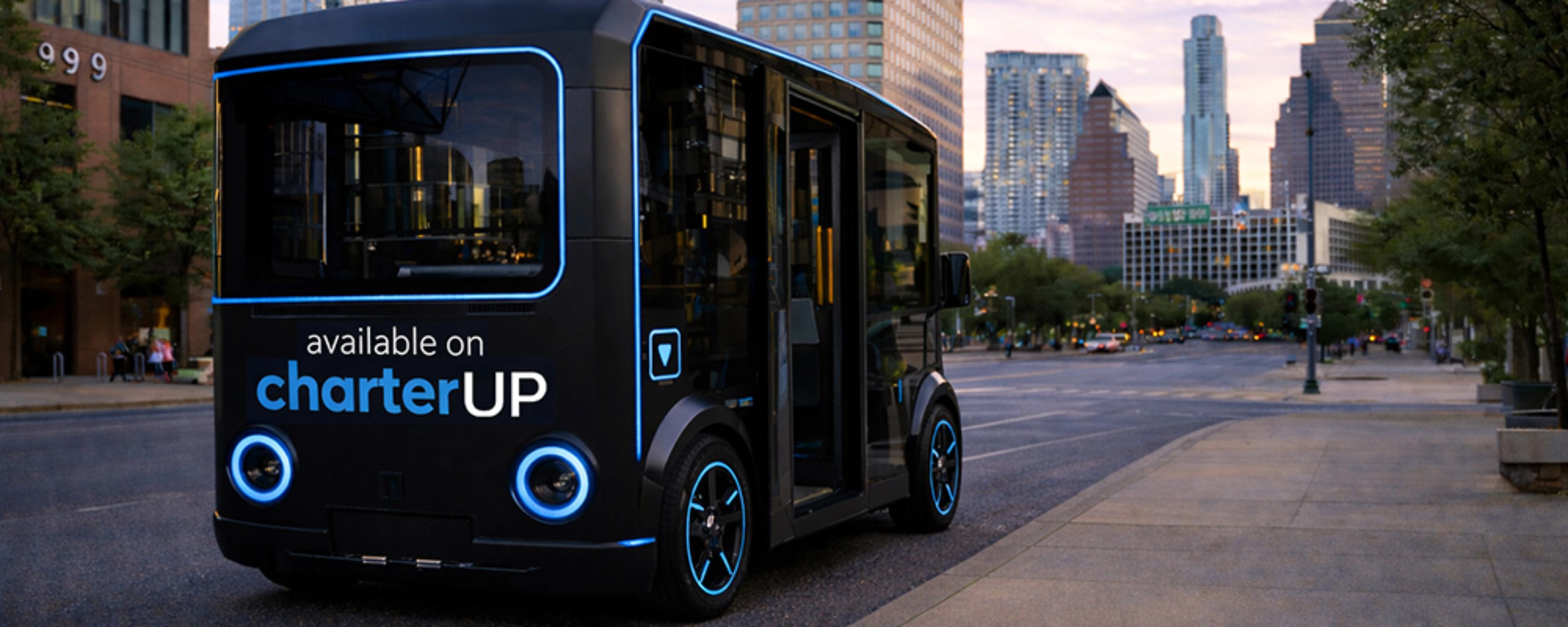 Small black electric shuttle bus with CharterUP logo in city street.
