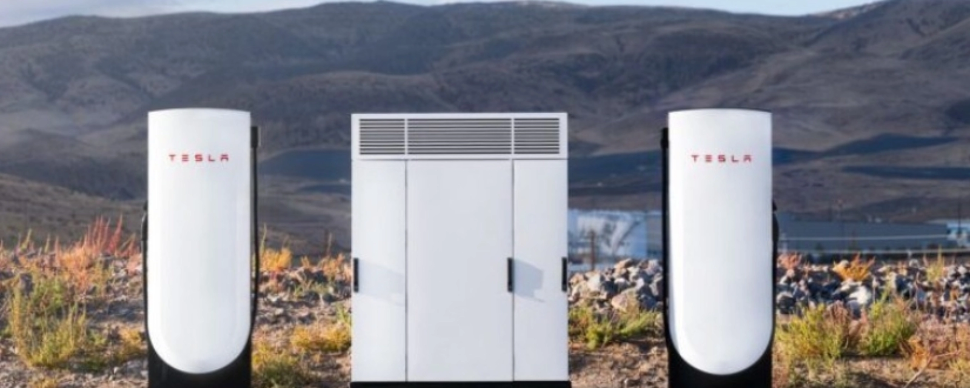 Tesla Supercharger station with two charging posts and a central power unit in a parking lot.