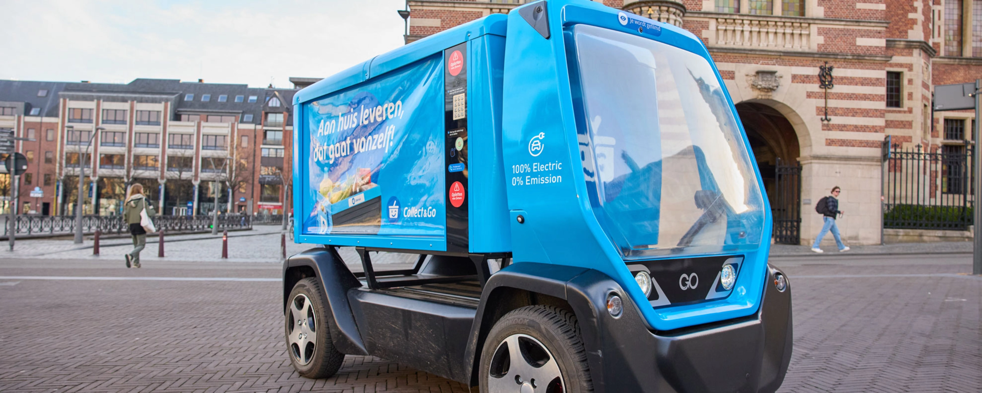 Kleines blaues Elektro-Müllfahrzeug auf einem Stadtplatz.