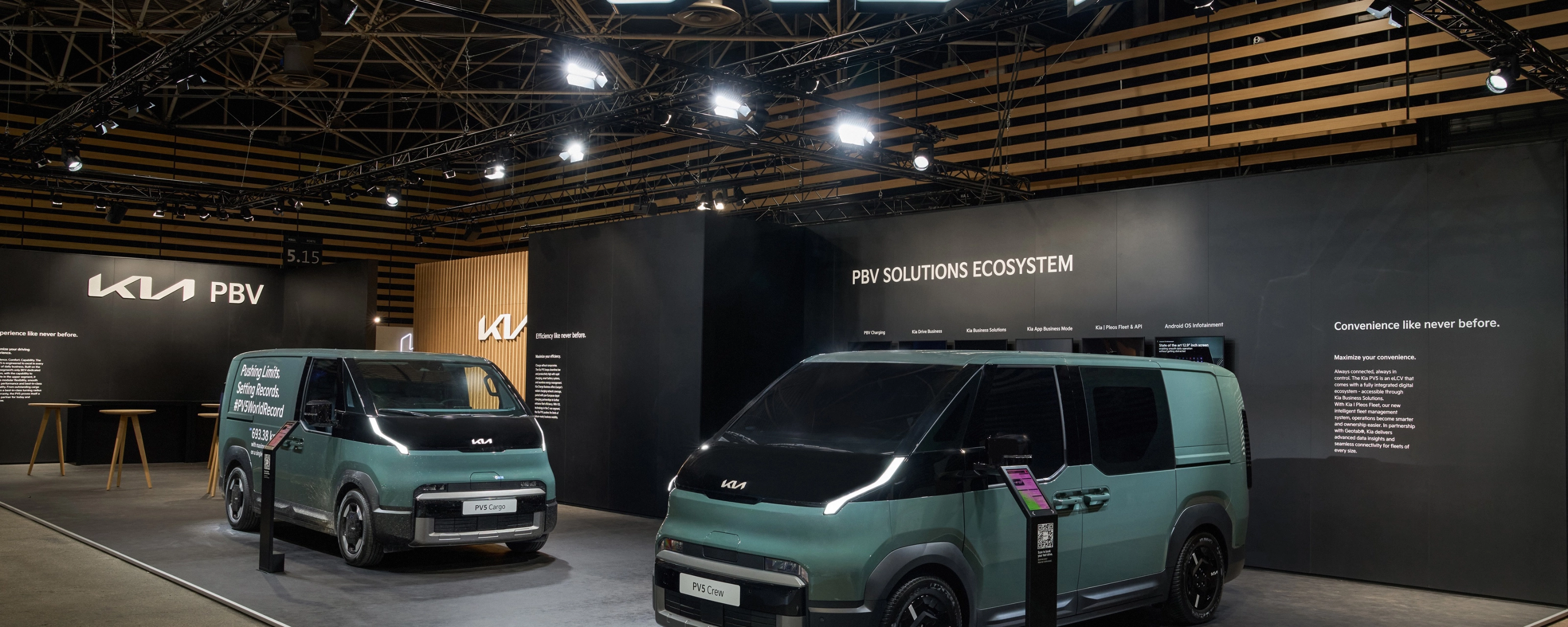 Zwei grüne Kia PBV Transporter stehen auf einem Messestand mit Kia-Logo.