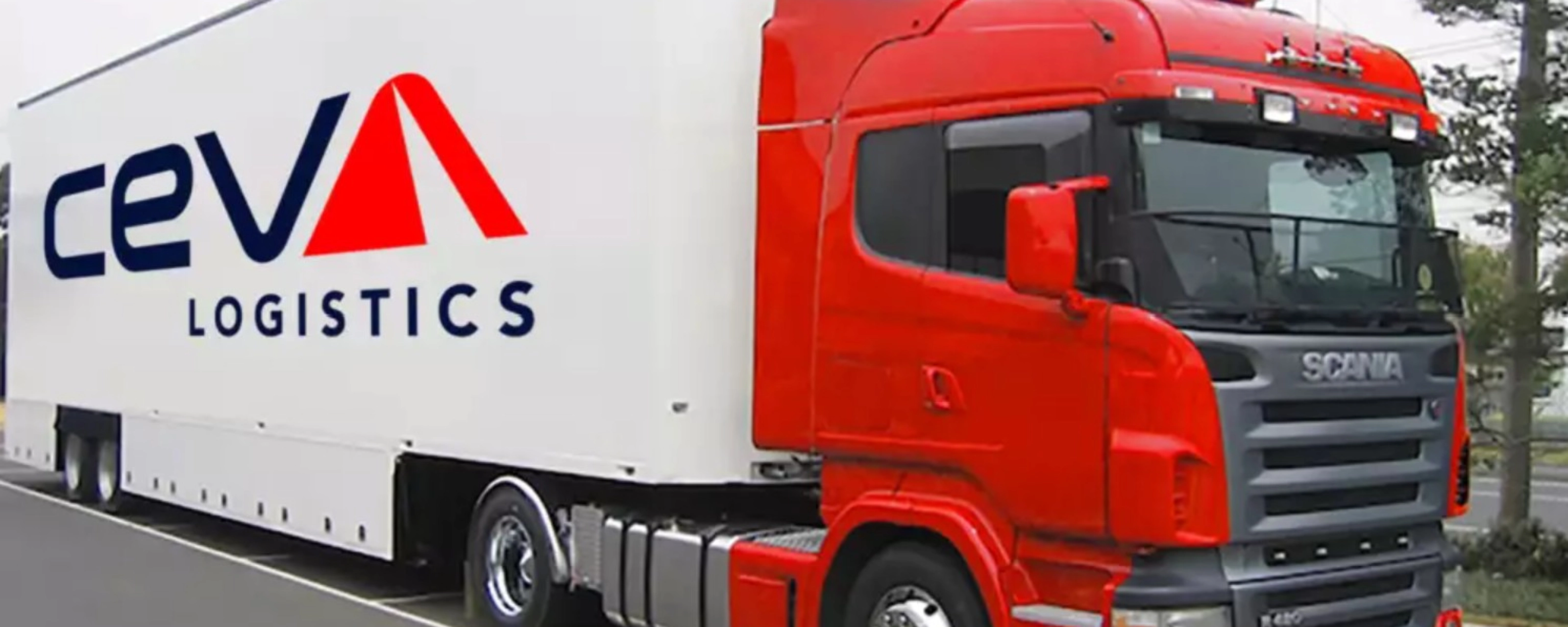A red CEVA Logistics truck with trailer is parked on a street.