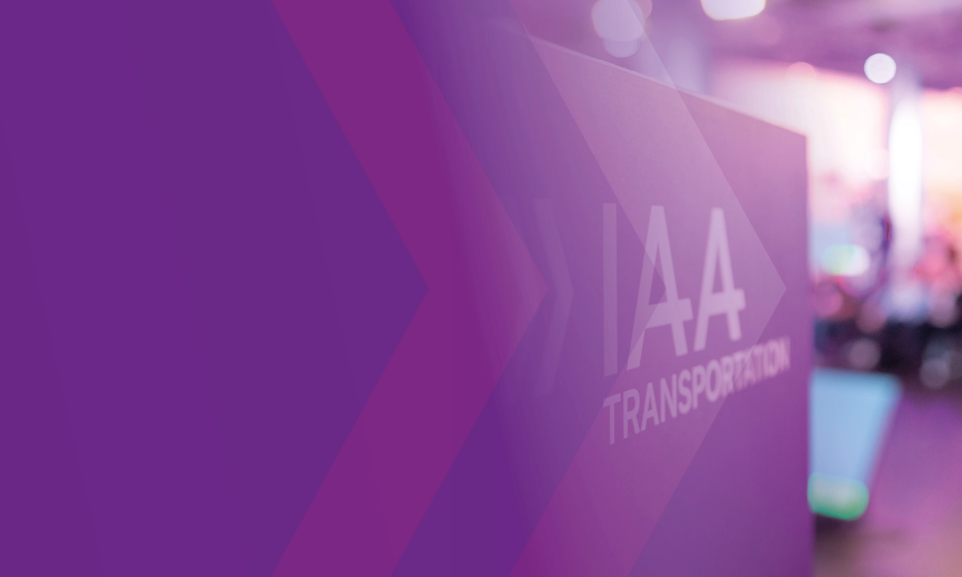 Schild mit der Aufschrift „IAA TRANSPORTATION“ auf einer Messe, lila Gestaltung im Vordergrund.