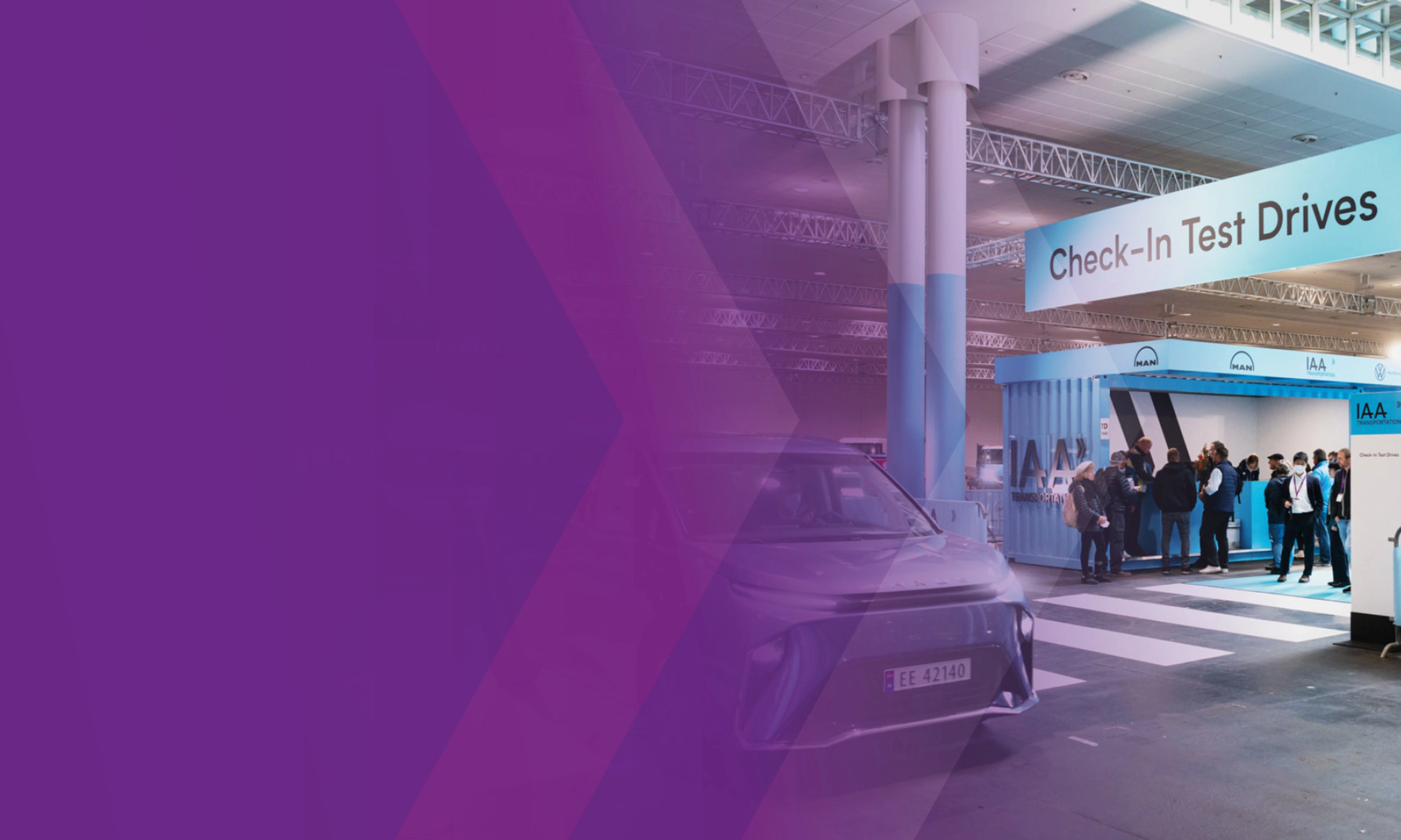 Check‑in‑Bereich für Probefahrten der IAA Transportation mit Fahrzeug und Personen in einer Halle.