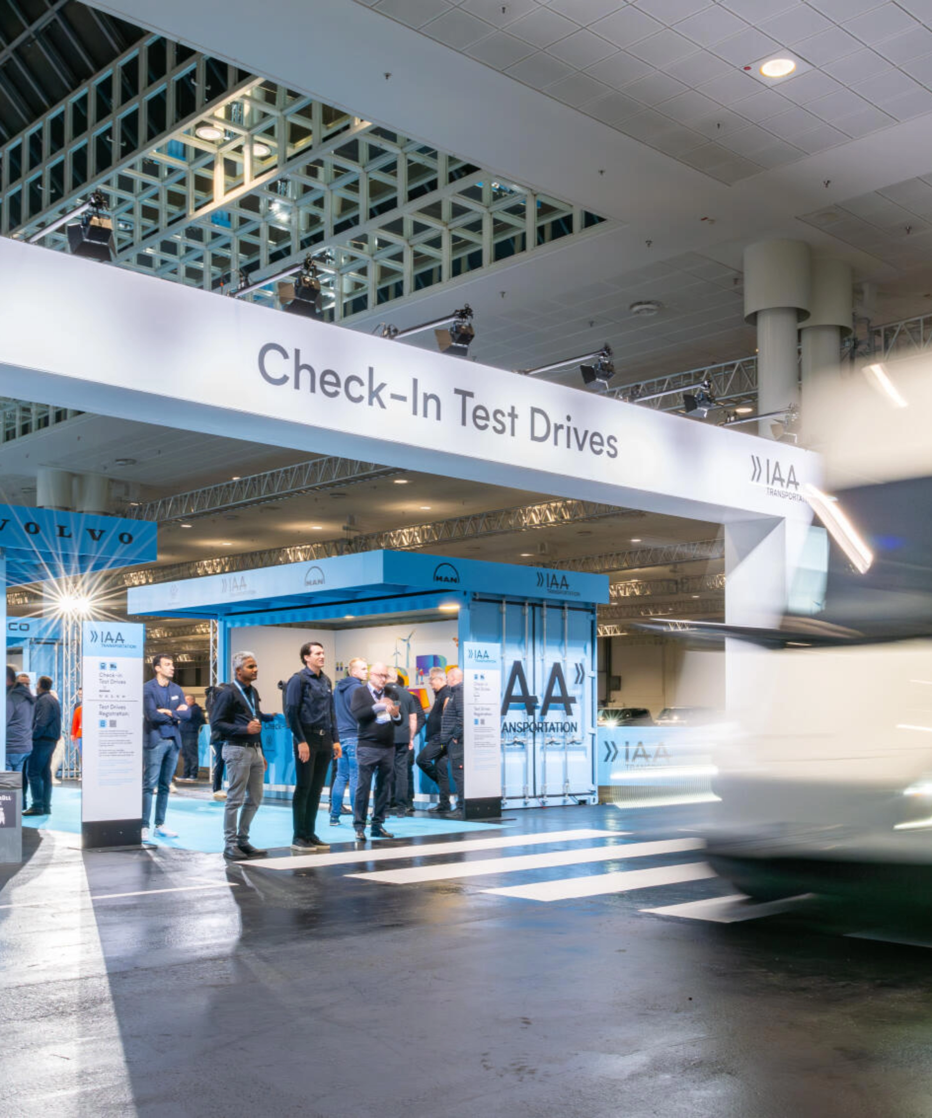 IAA Transportation Check-In area for test drives with truck passing by.