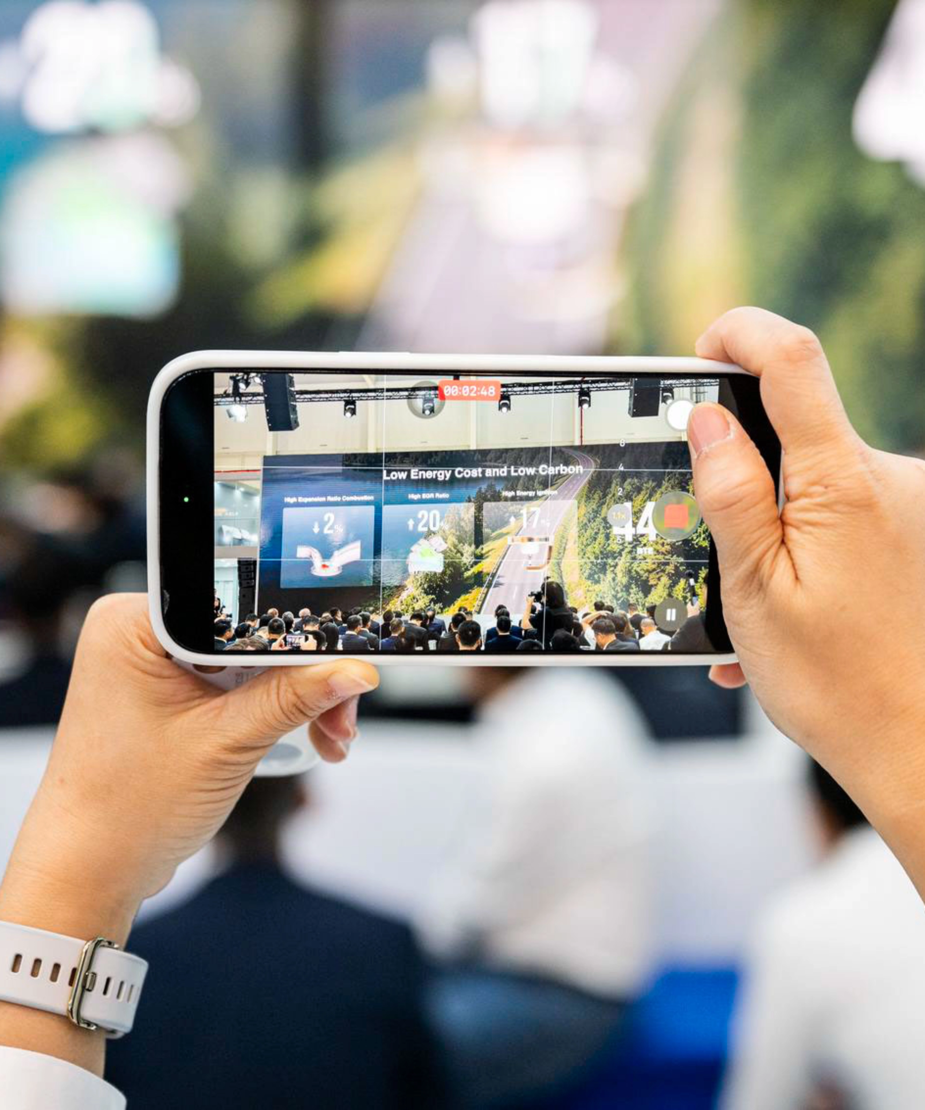 Person taking a photo of an event with a smartphone.