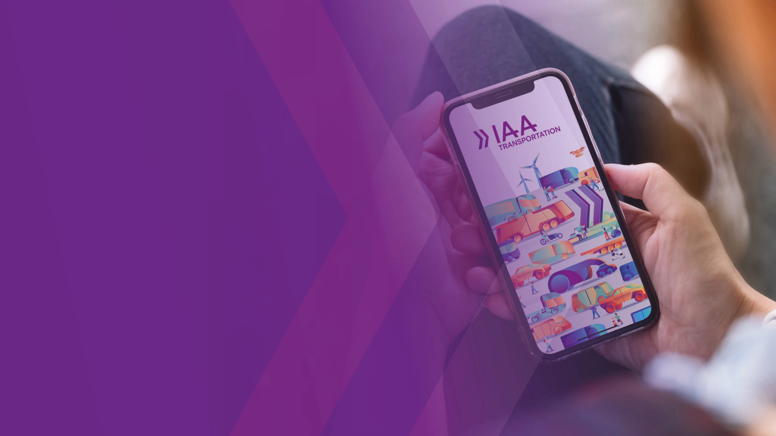 A person holds a smartphone showing a colorful app screen with the text IAA.
