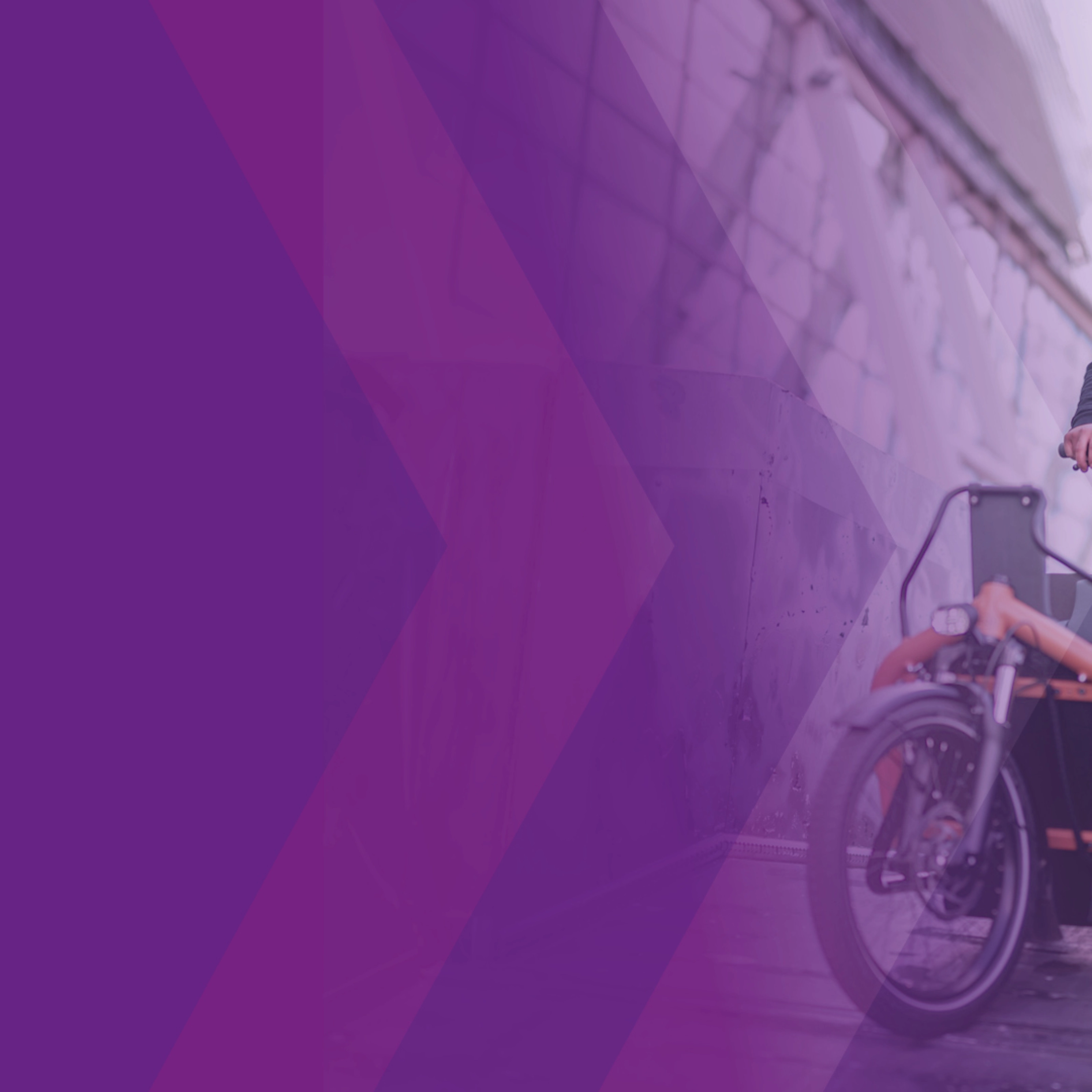 Man riding a cargo bike down a ramp at an outdoor event.