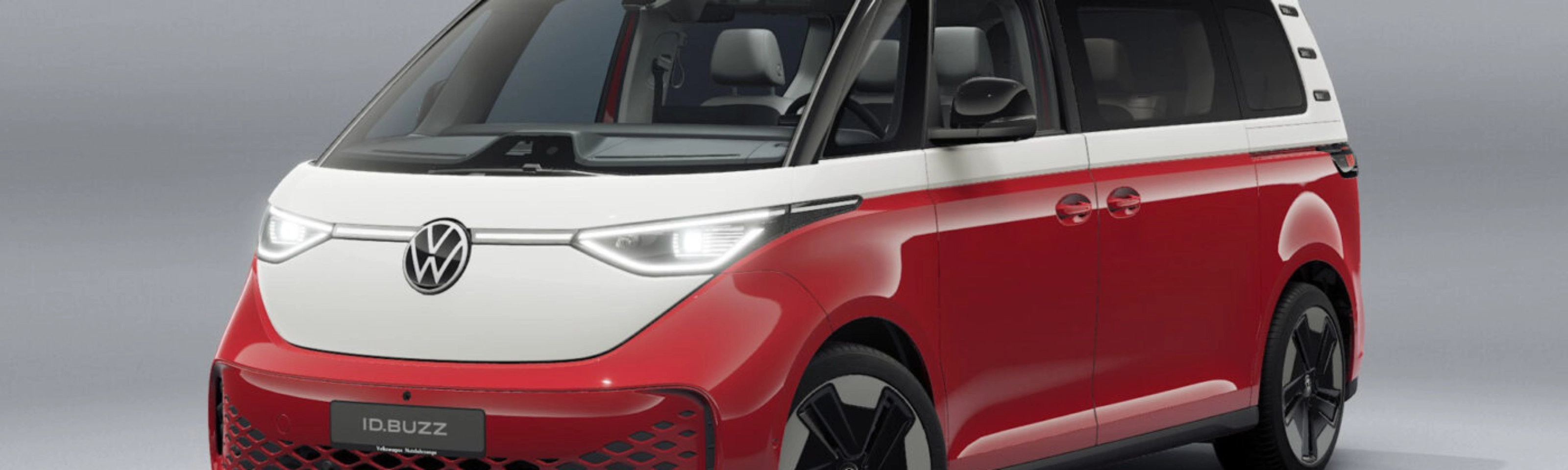 Rot-weißer Volkswagen Van in Frontansicht vor neutralem Studiohintergrund.
