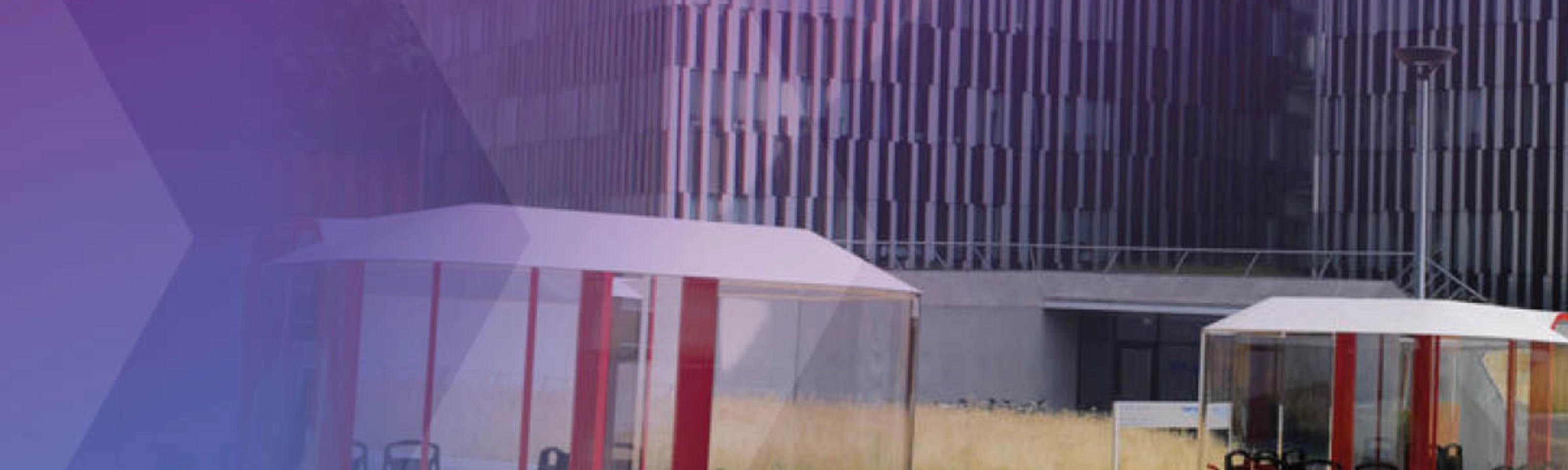 Several futuristic cable cars and ground pods are shown near a modern office building.