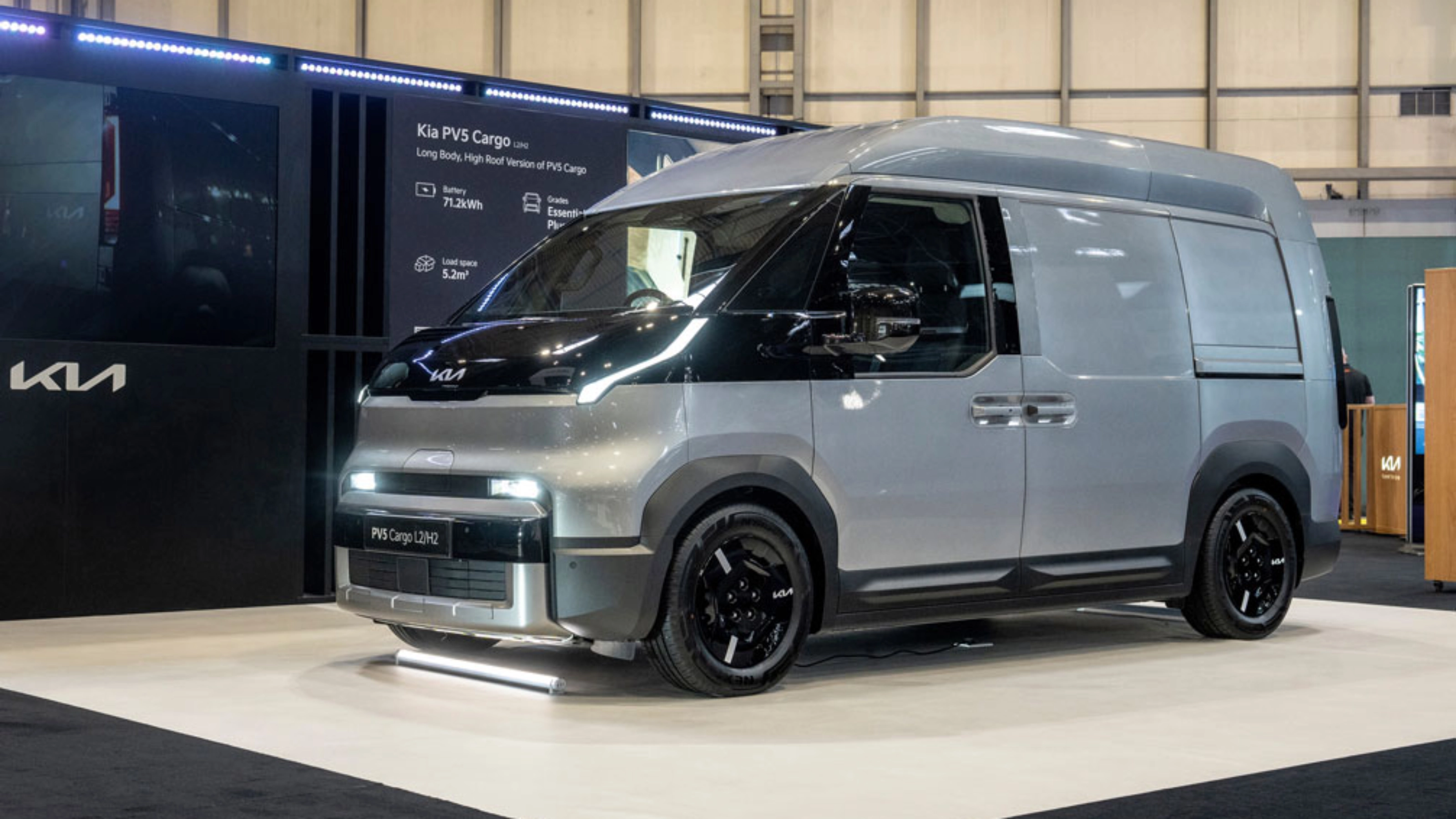 Kia PV5 Cargo van displayed at an indoor exhibition stand.