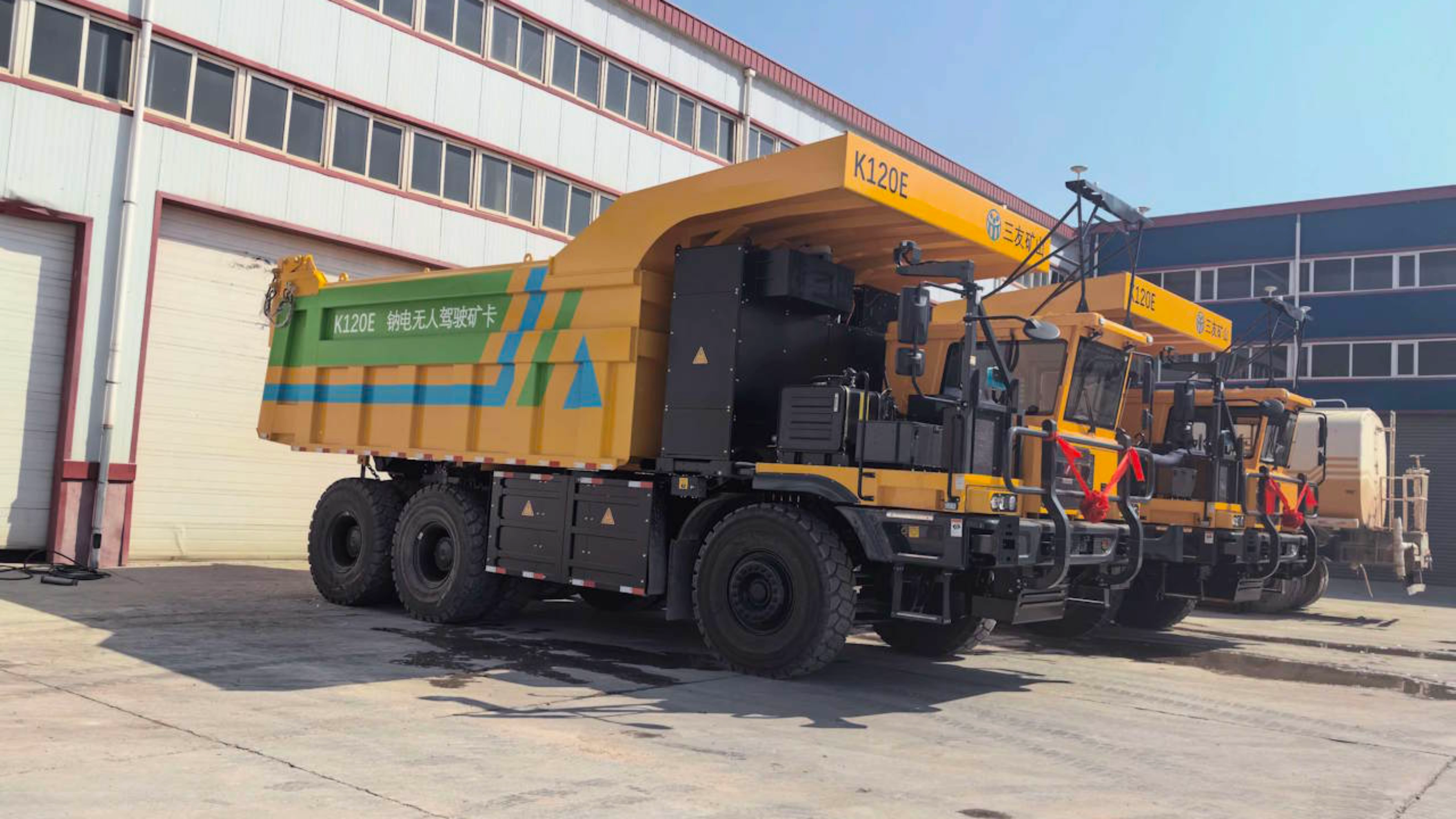 Elektrischer Hina-Battery-Muldenkipper steht auf einem Betriebsgelände.