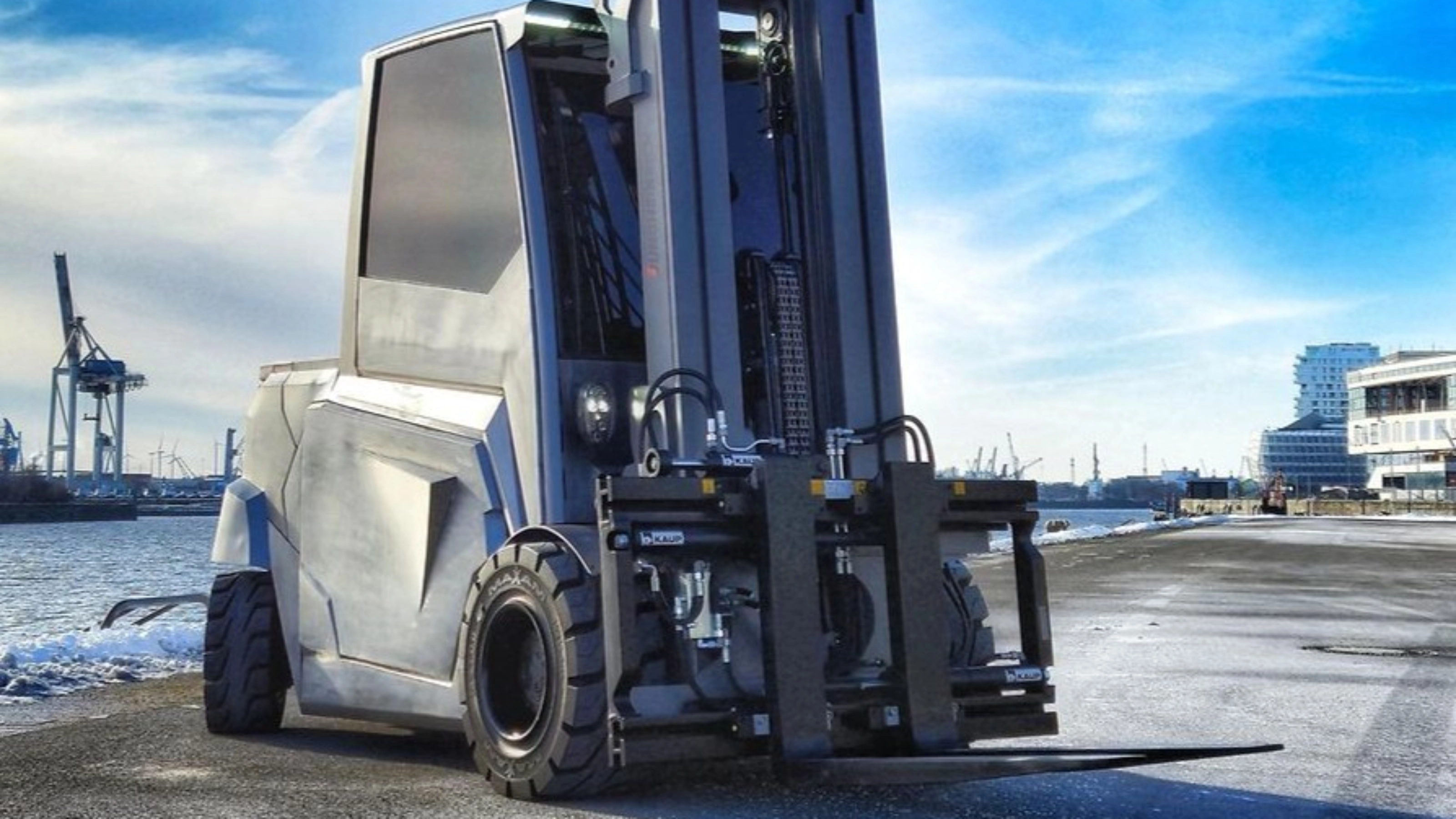 Large industrial forklift parked at a harbor loading area.