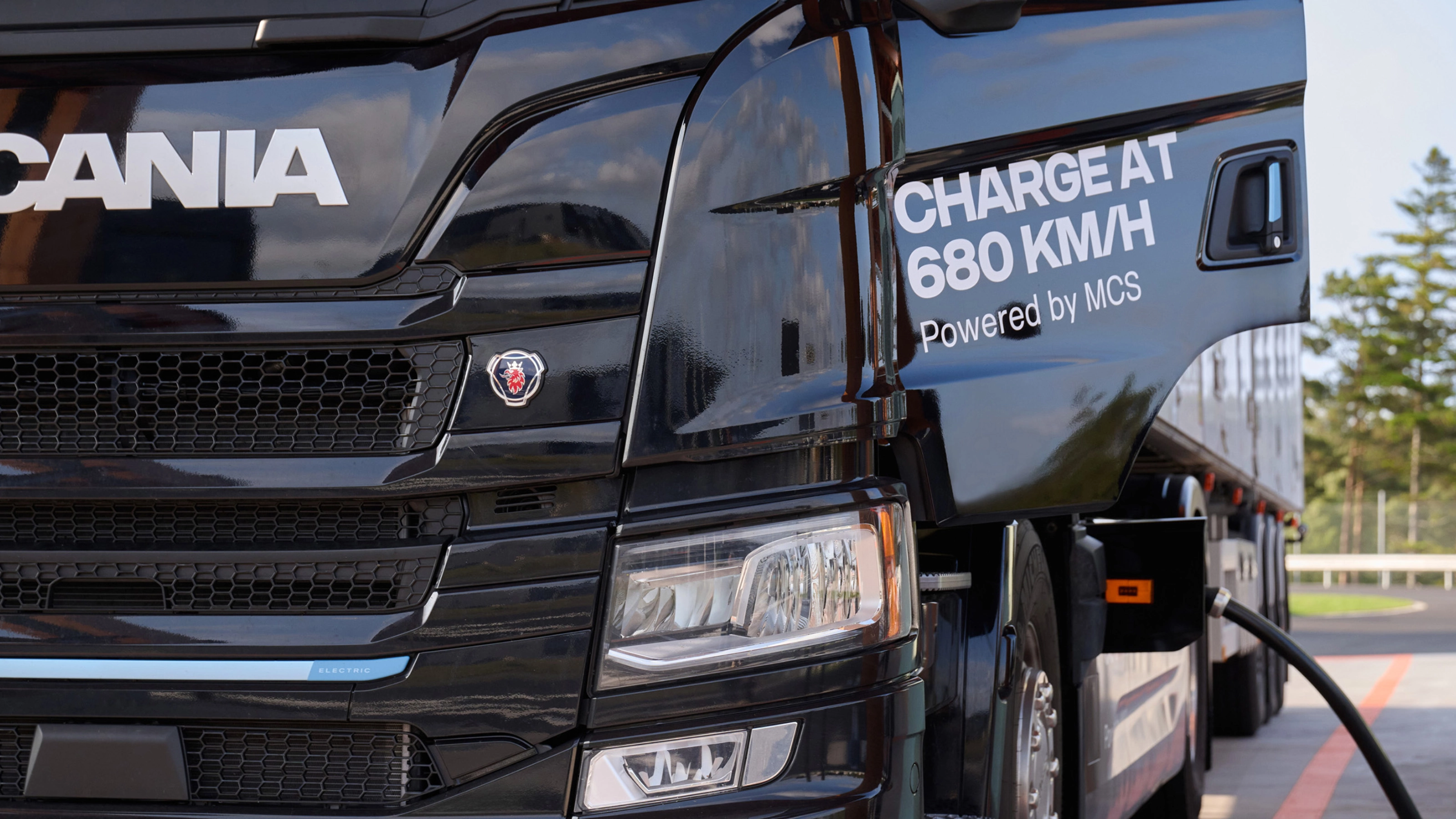 Scania Elektro-Lkw lädt an Station mit angeschlossenem Kabel.