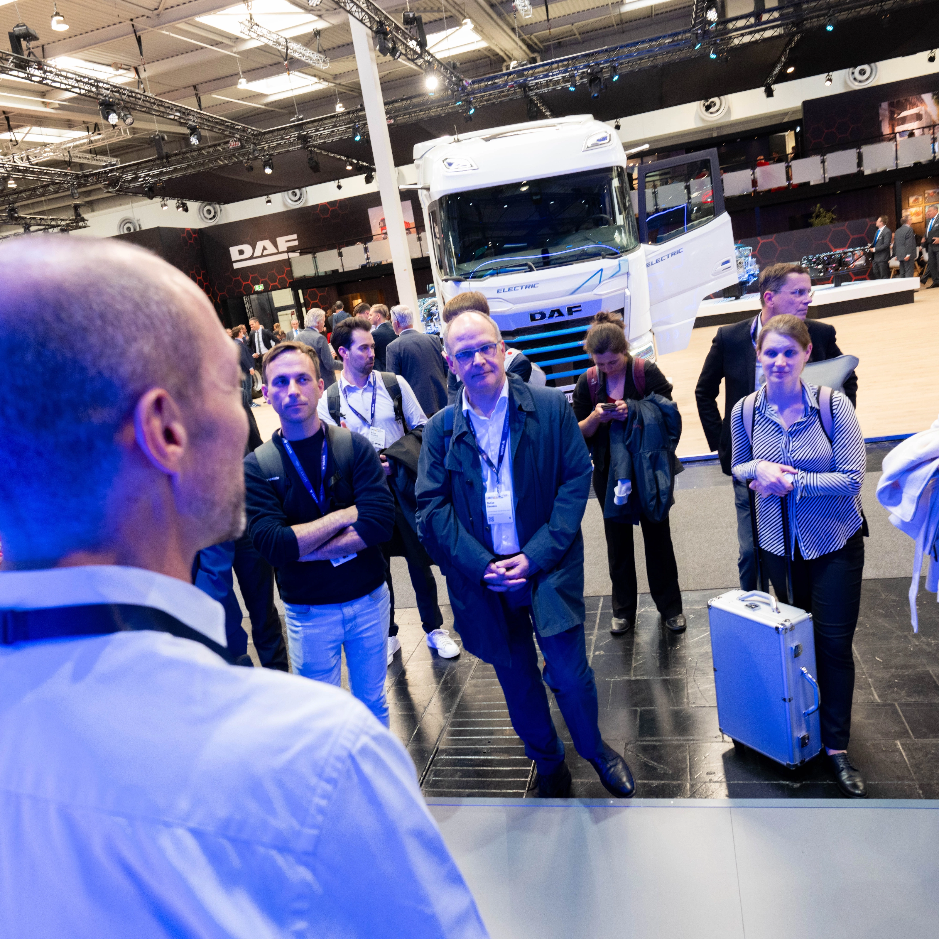 Besucher verfolgen eine Präsentation am DAF-Lkw-Messestand.