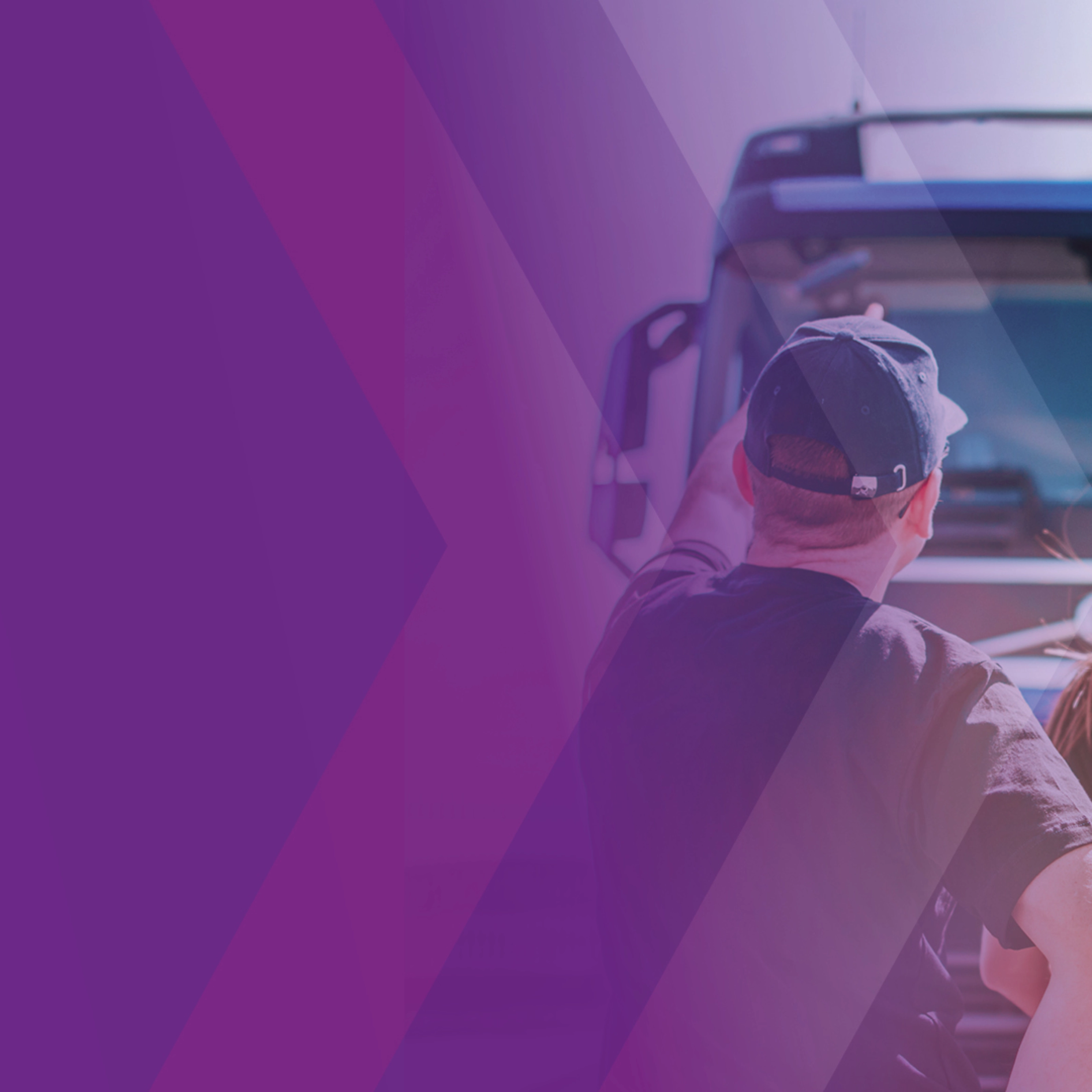 Zwei Personen stehen vor einem Lkw, teilweise von violettem Overlay überlagert.