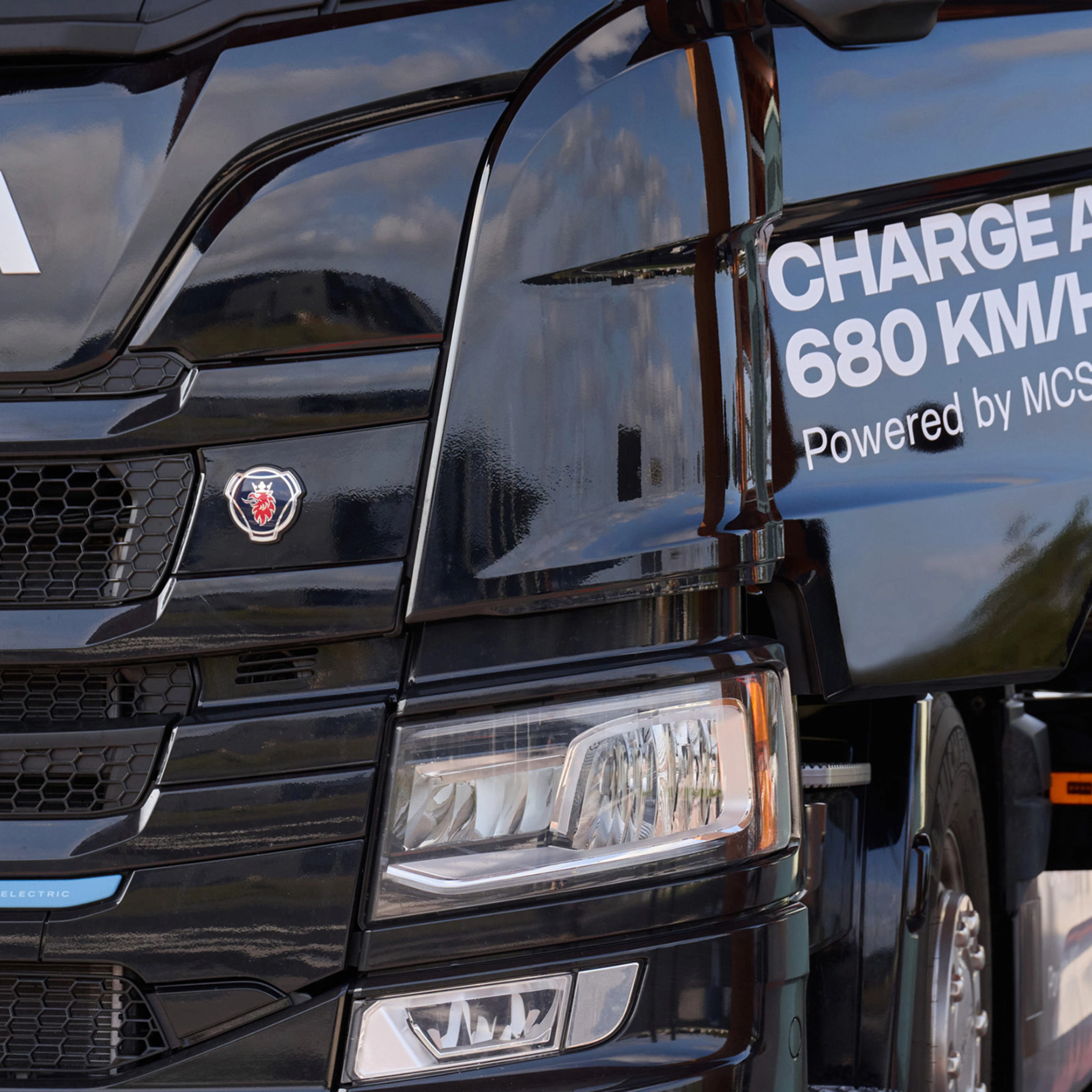 Scania Elektro-Lkw lädt an Station mit angeschlossenem Kabel.