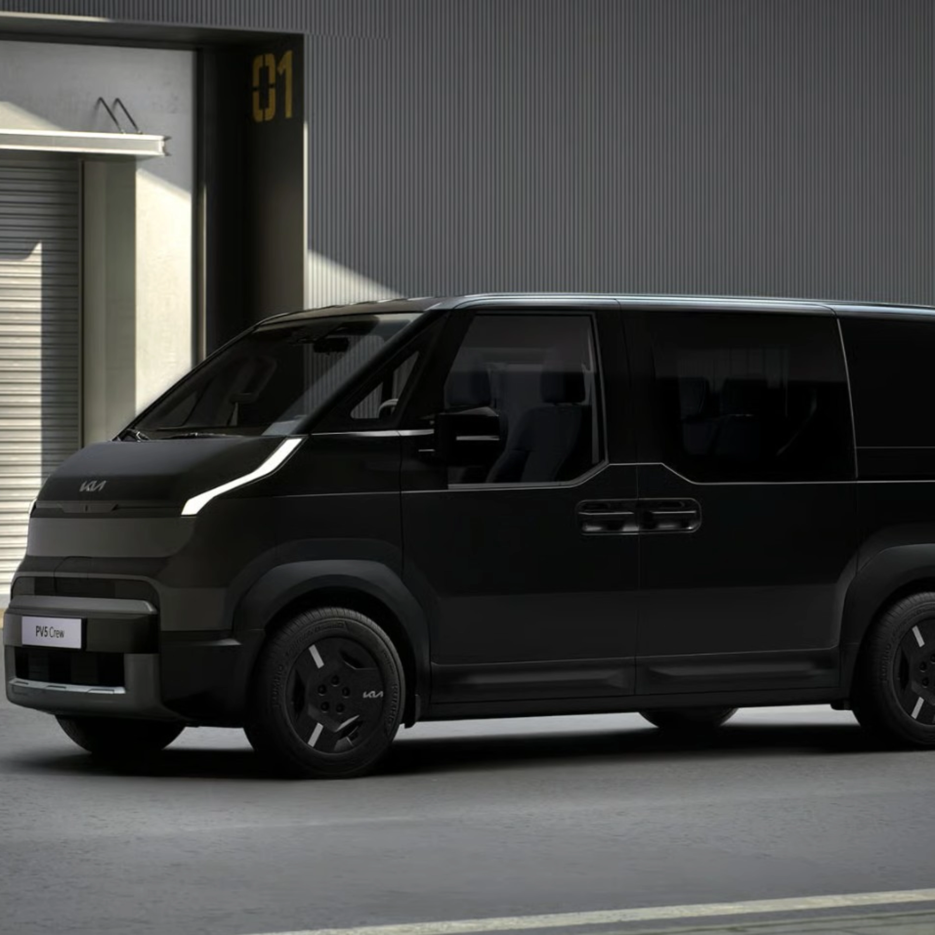 Schwarzer Kia-Van steht vor Industriegebäuden mit geschlossenen Rolltoren.