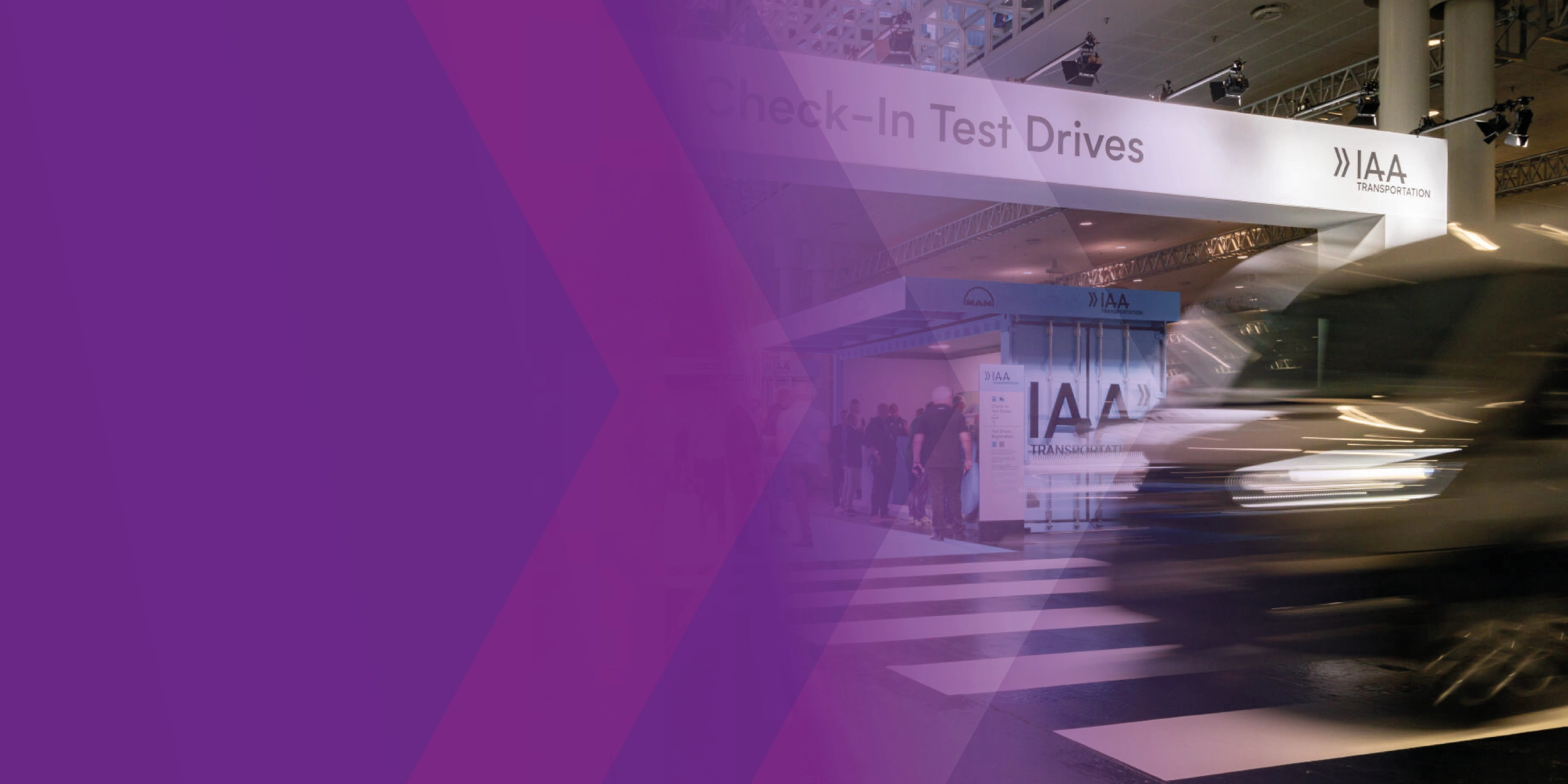 Ein unscharfes Fahrzeug fährt an der Testdrive-Check-in-Zone der IAA vorbei, teils überlagert von lila Grafikflächen.